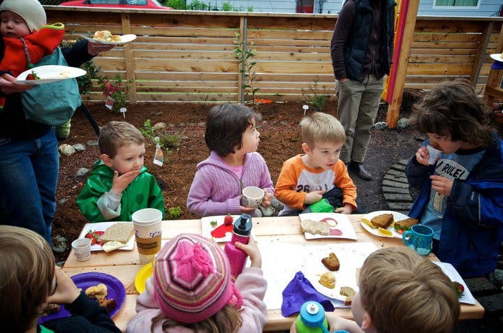 Children eating at a table outdoors