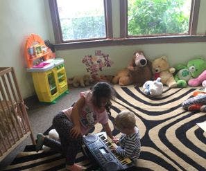 Person and child playing with a keyboard on a rug