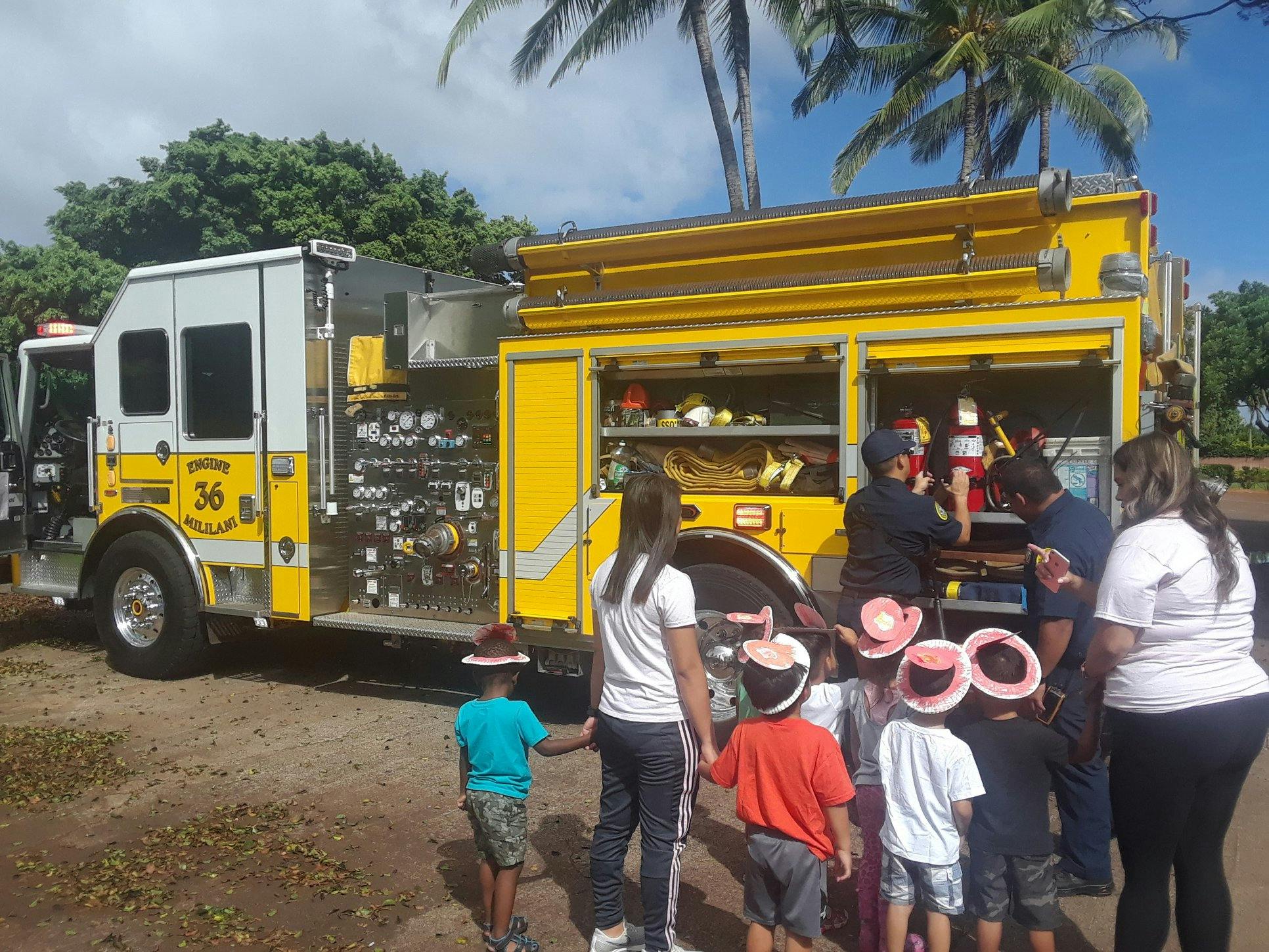People and children gathered around a fire truck