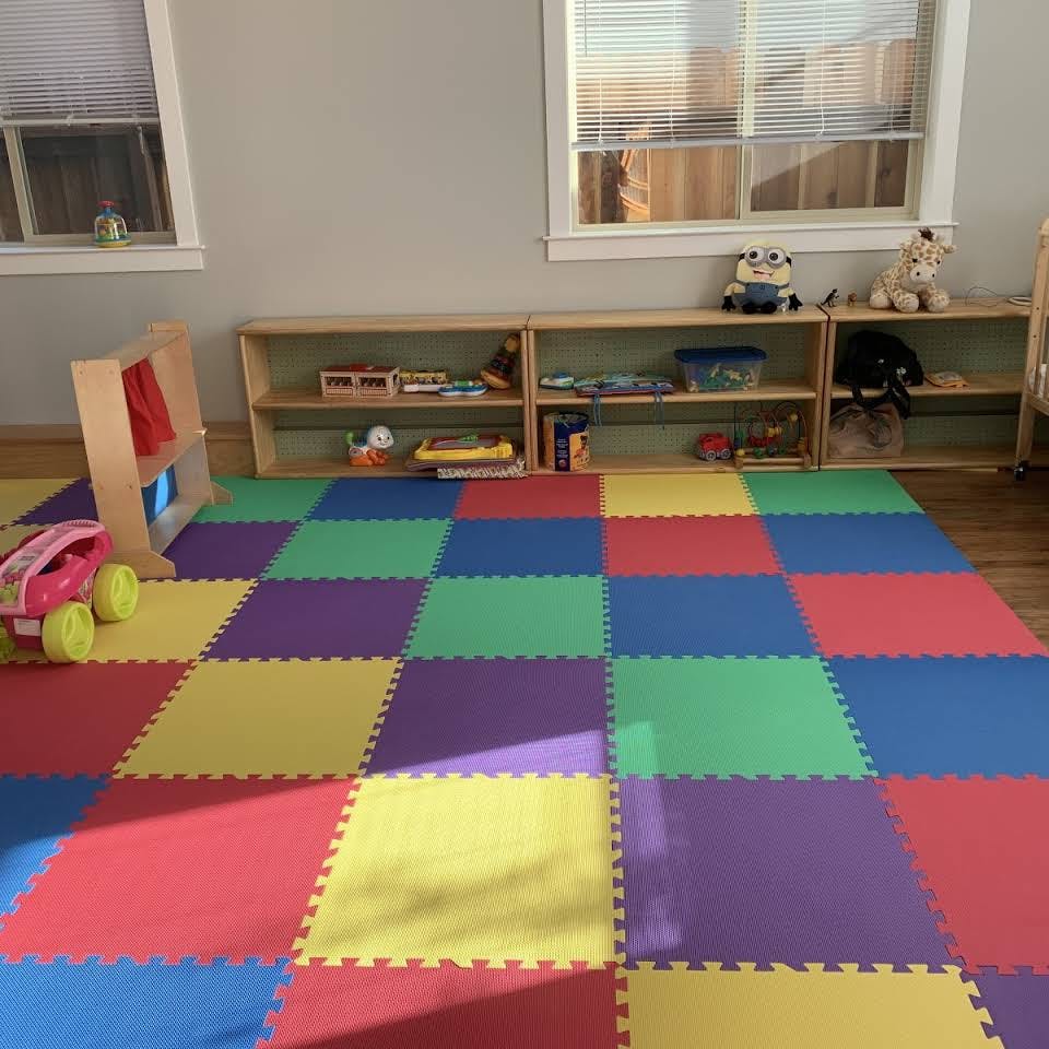 Playroom with colorful interlocking floor mats and shelves with toys