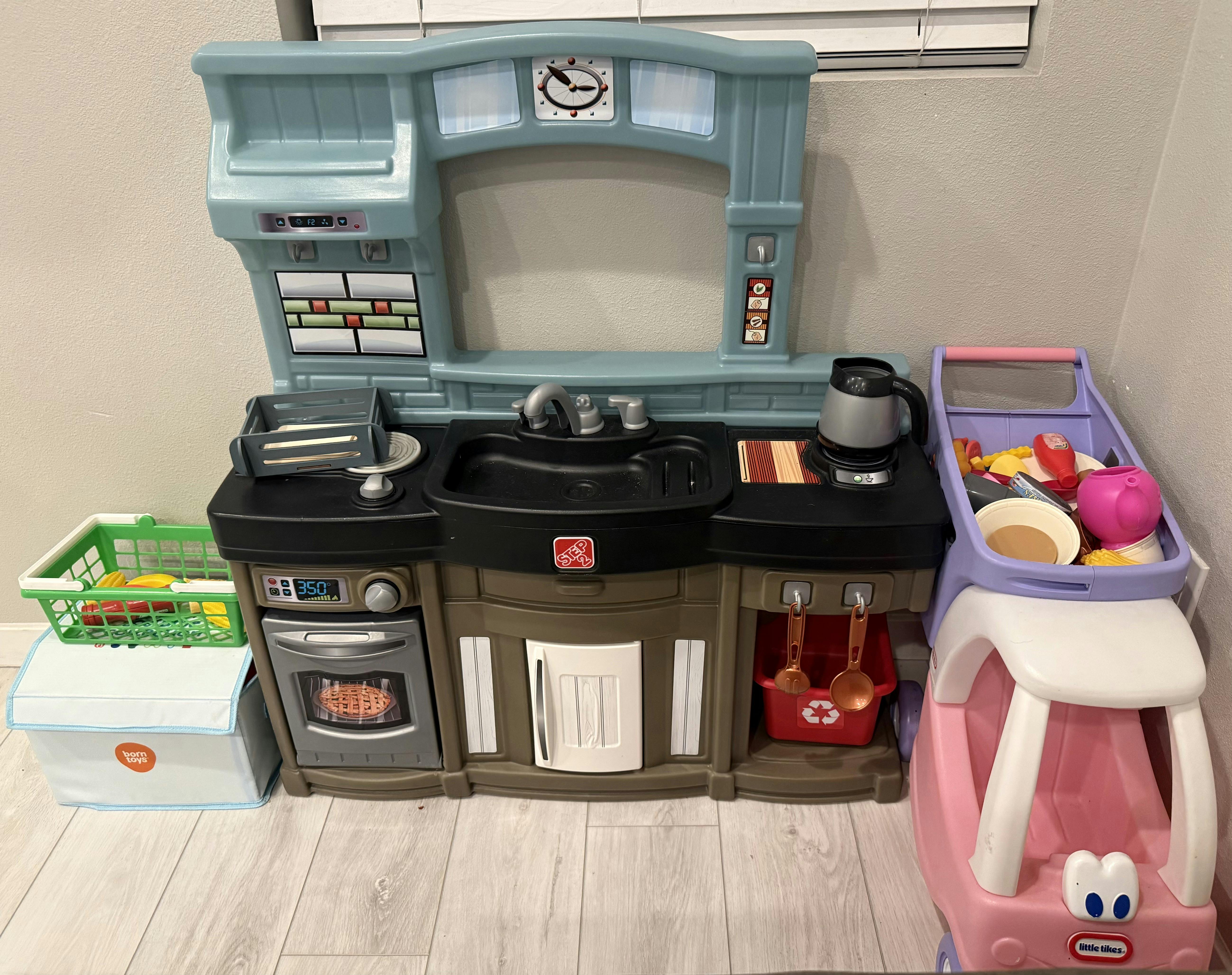 Plastic toy kitchen playset with play accessories and a toy shopping cart