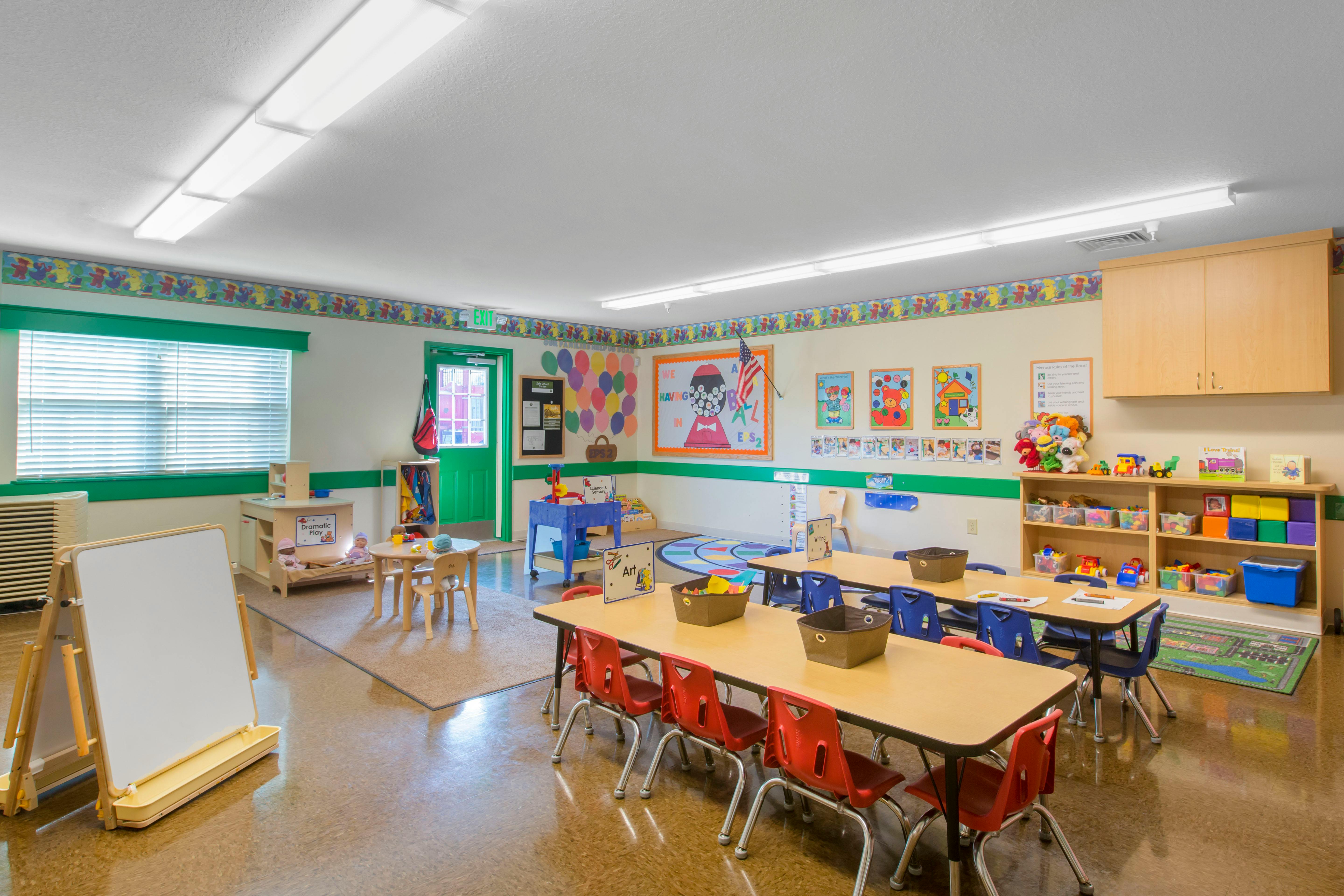 Empty colorful preschool classroom with small tables and chairs