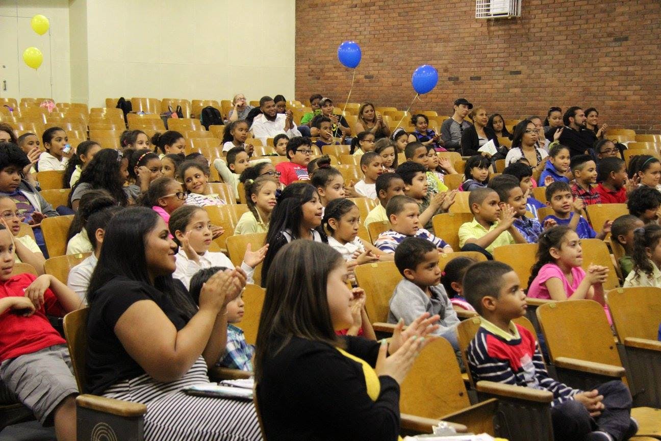 Audience of adults and children sitting in an auditorium
