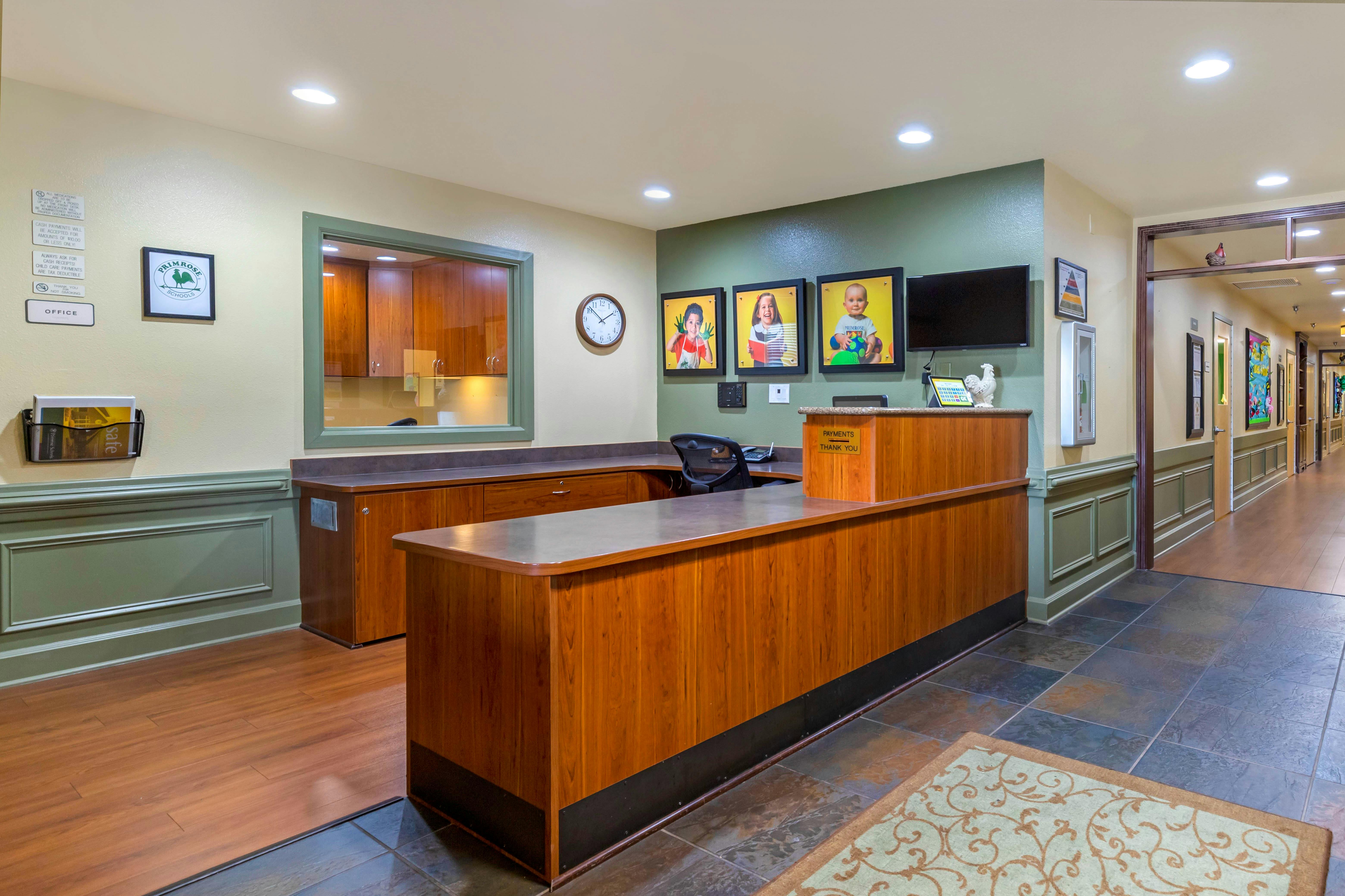 Reception desk with office behind a window and hallway extending