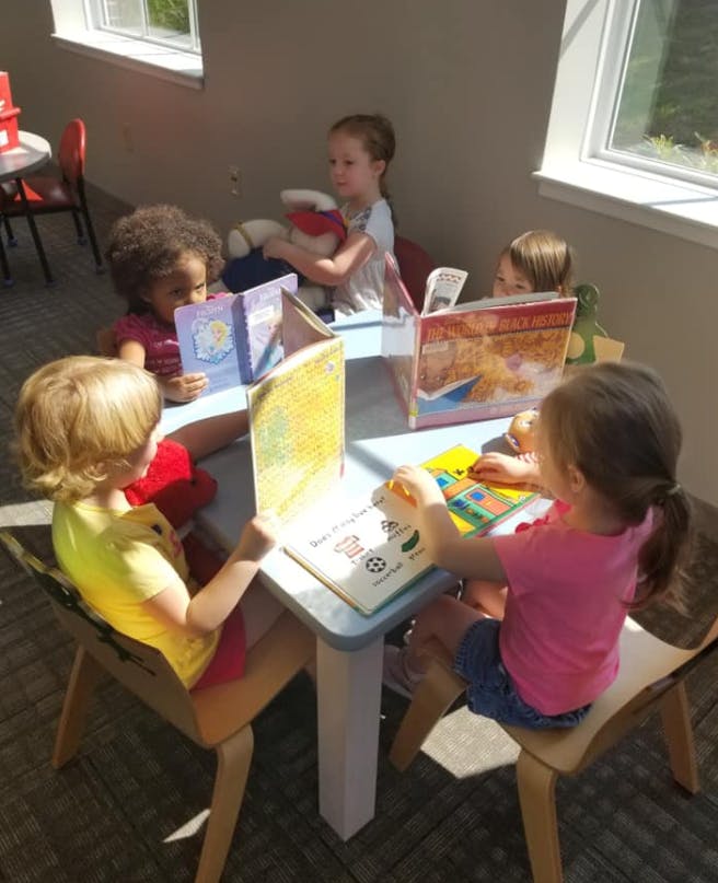 Children reading books at a table