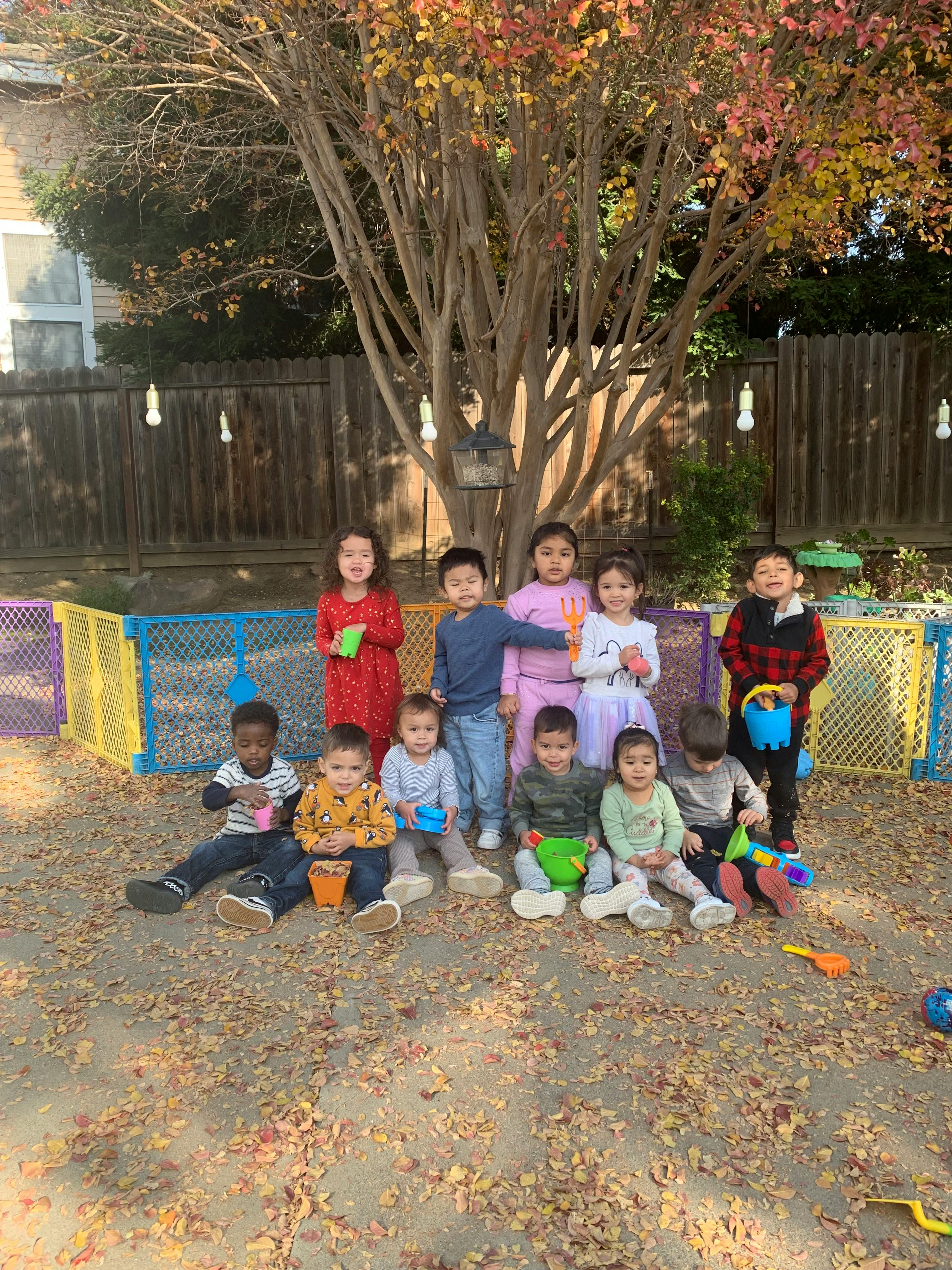 Group of children posing outdoors with toys