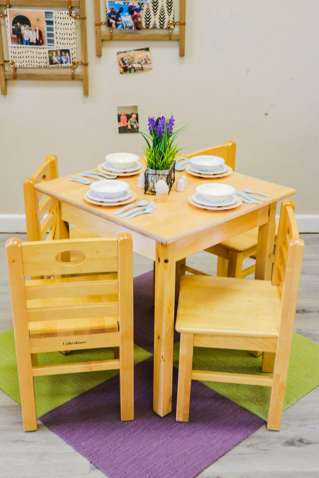 Small wooden table set with dishes and four chairs