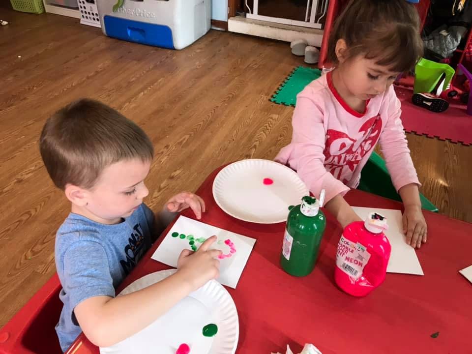 Two children painting at a table