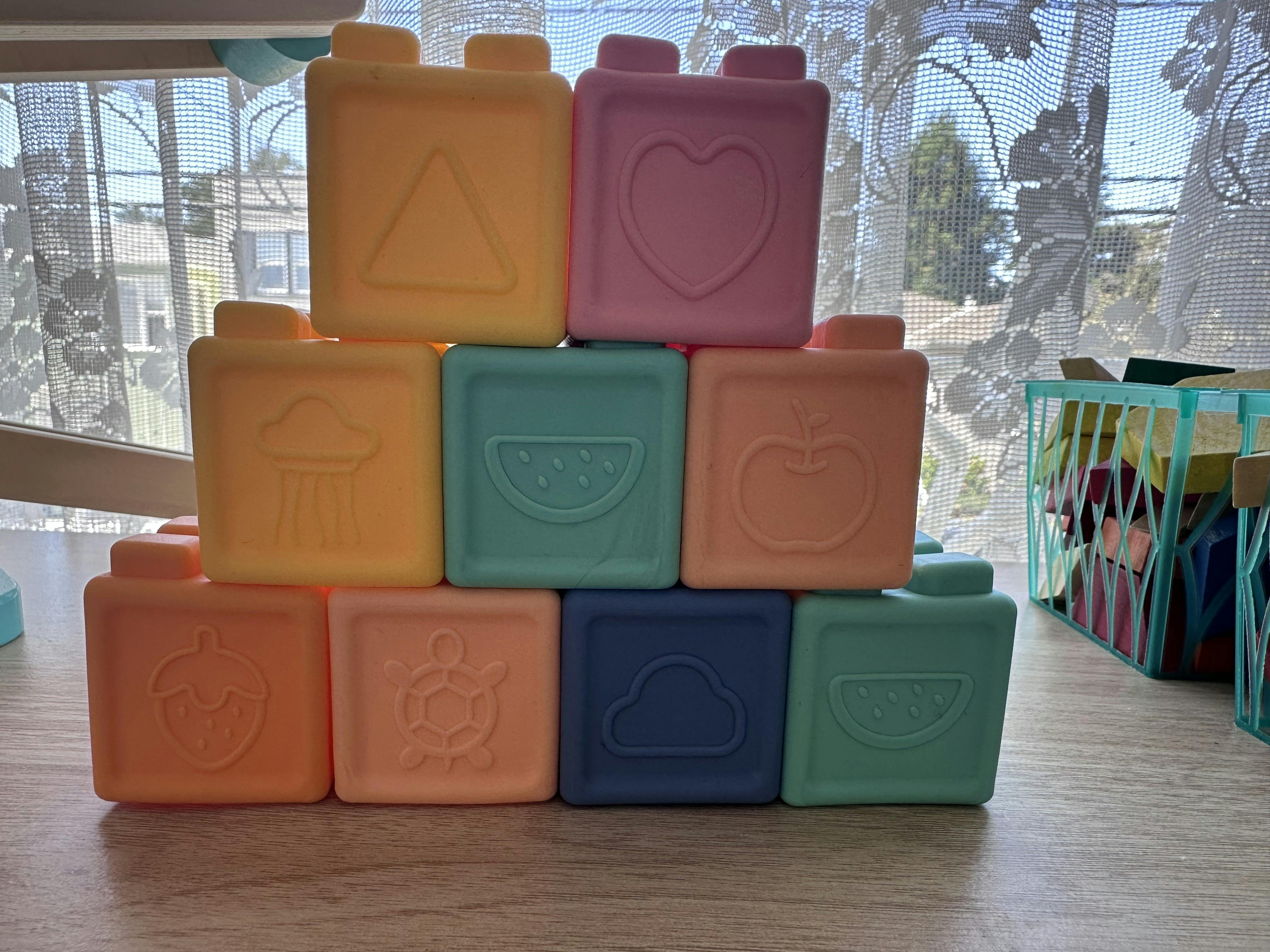 Stacked plastic building blocks with embossed shapes and figures