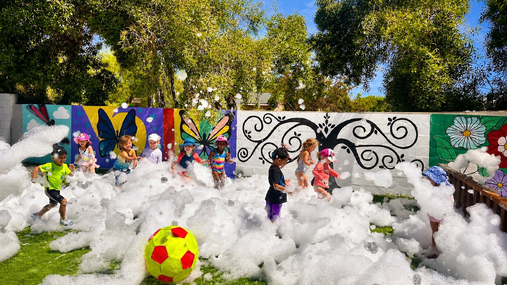 Group of children playing in foam in a backyard