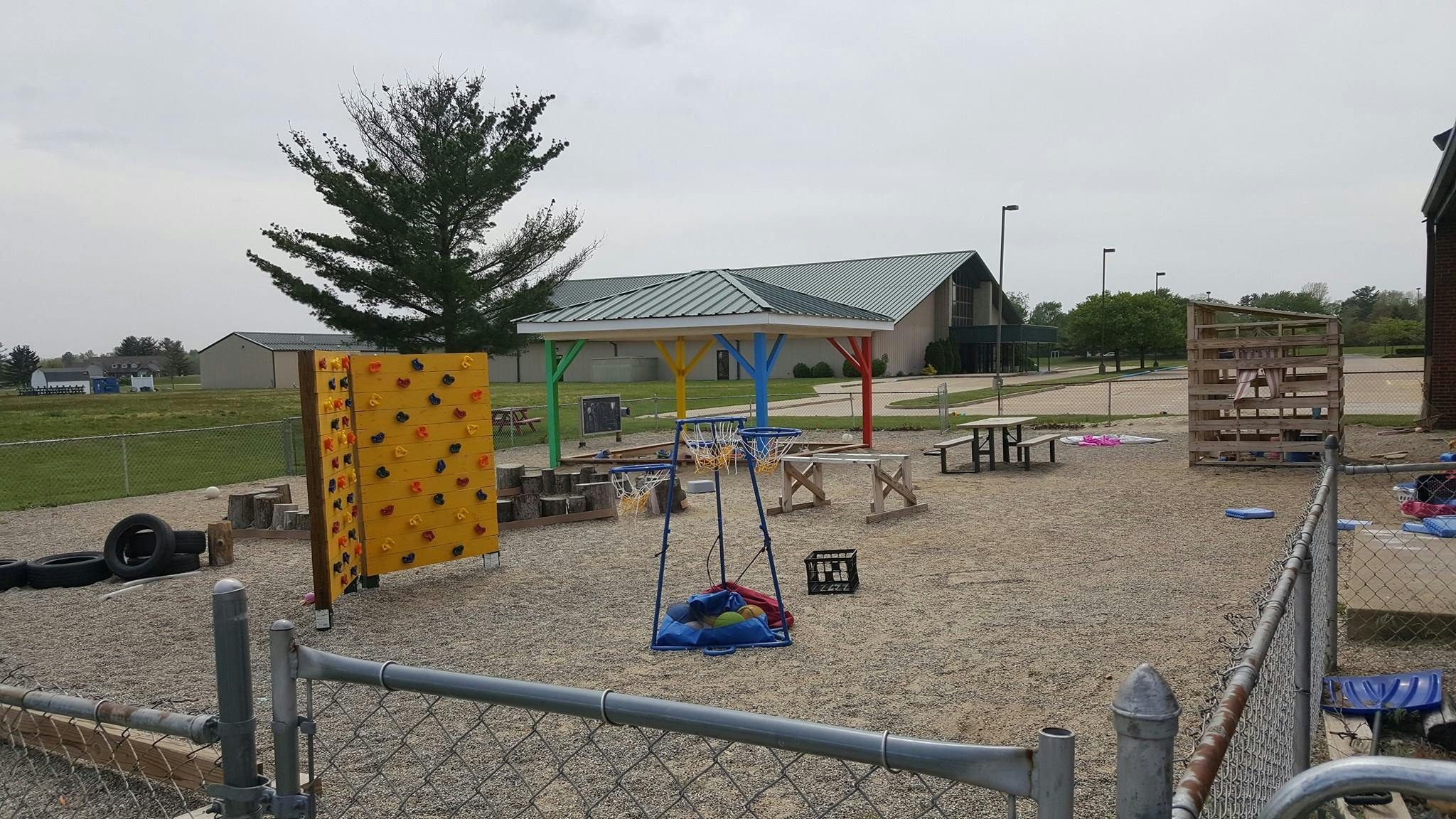 Outdoor play area with a yellow climbing wall and various play equipment