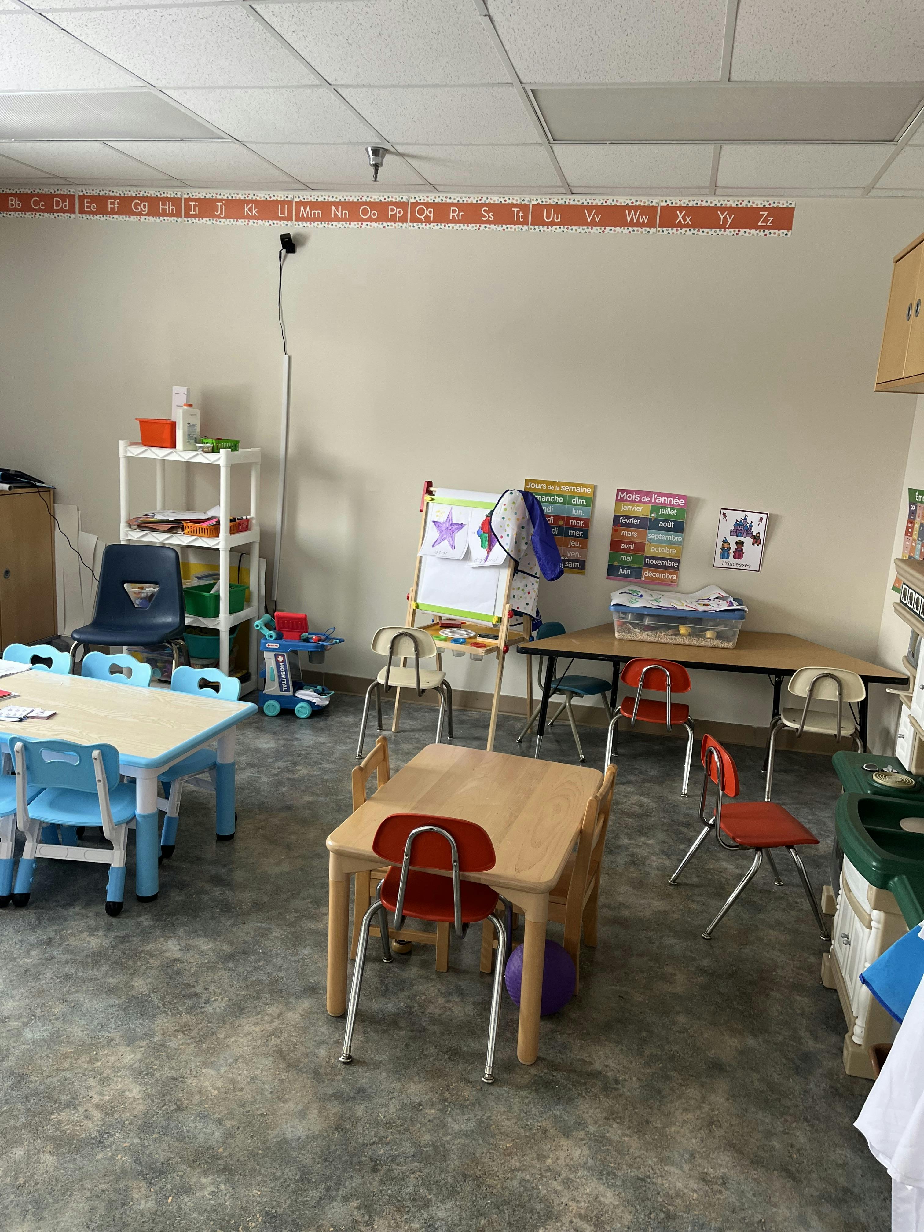 Children's classroom with small tables, chairs, and learning decorations