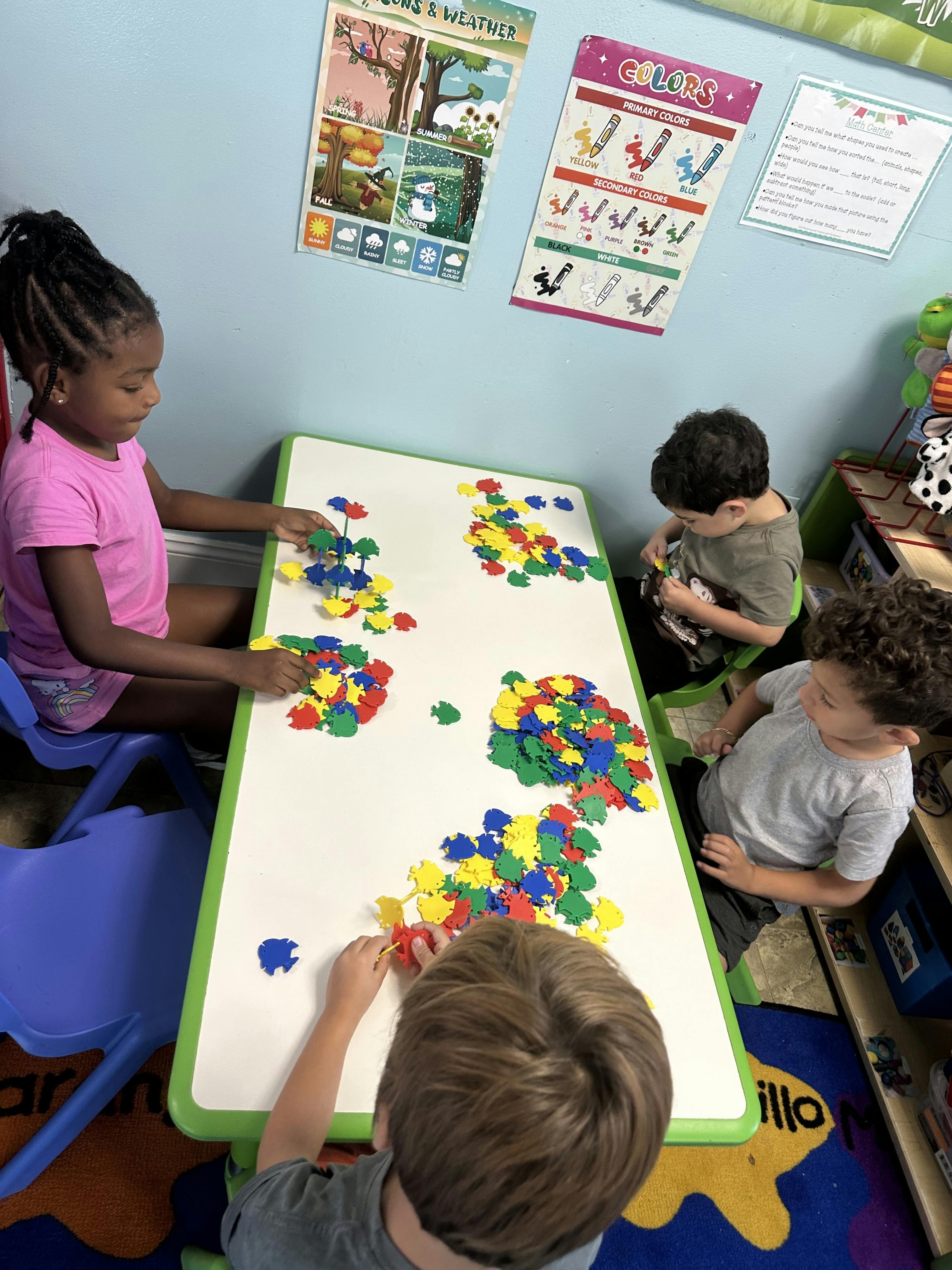 Children playing with colorful frog-shaped pieces on a table