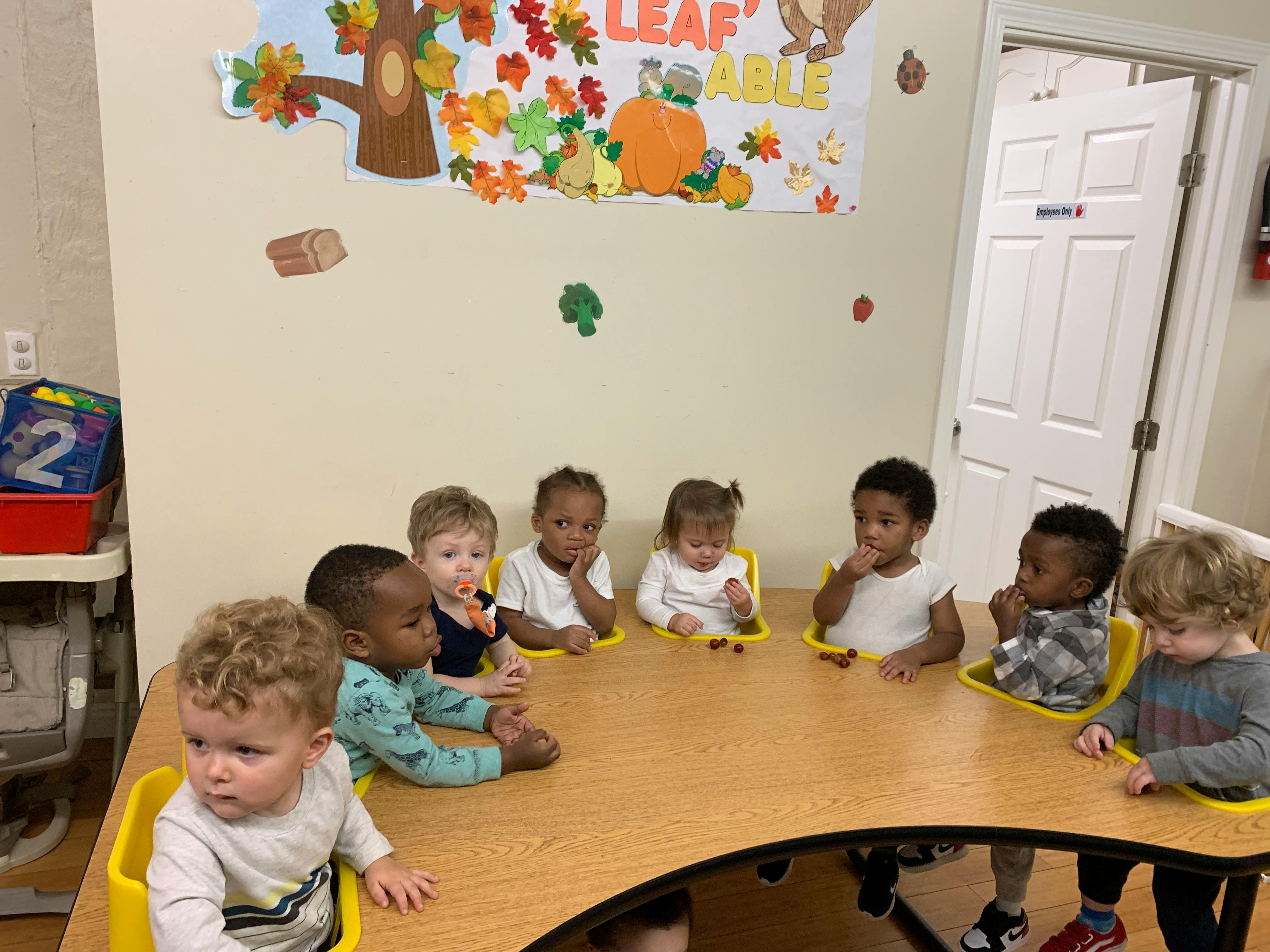 Group of children sitting around a table in a classroom