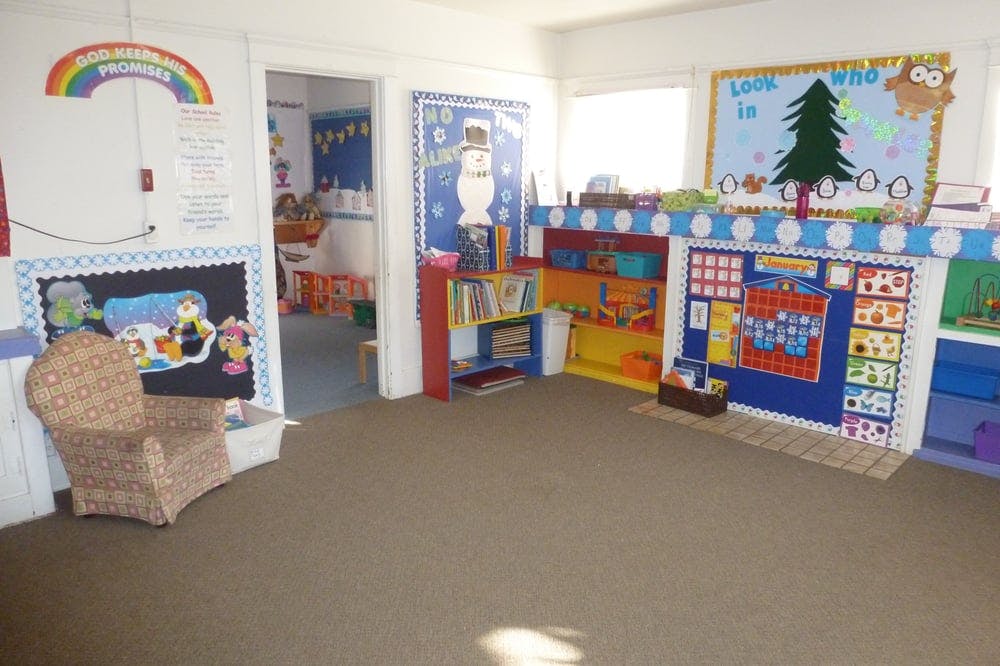 Classroom with colorful decorations, bookshelves, and a small chair