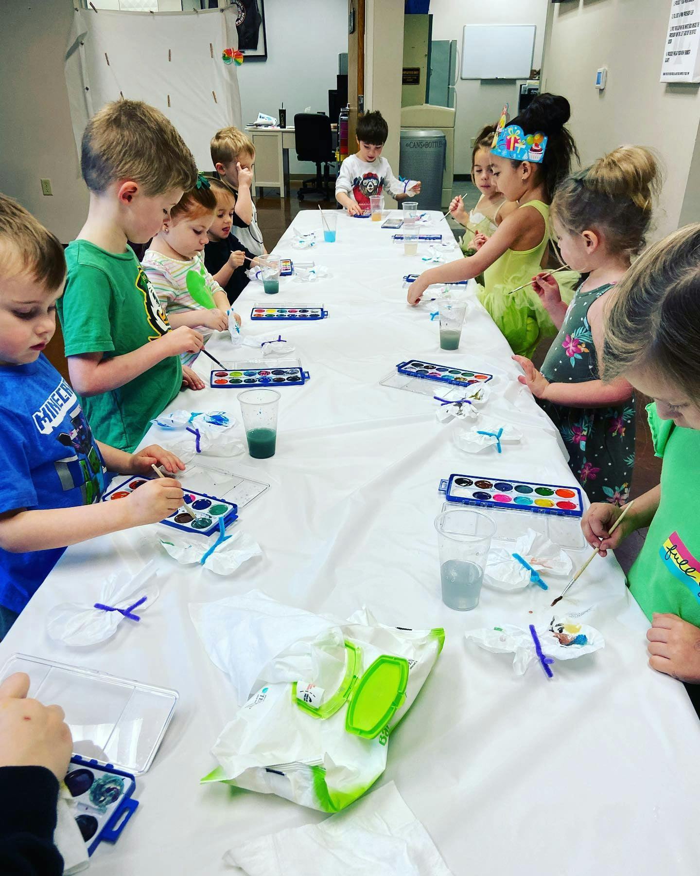Children painting at a long table