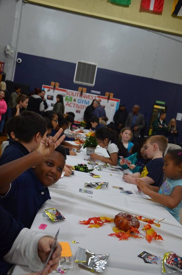 Children sitting at a long table with craft supplies