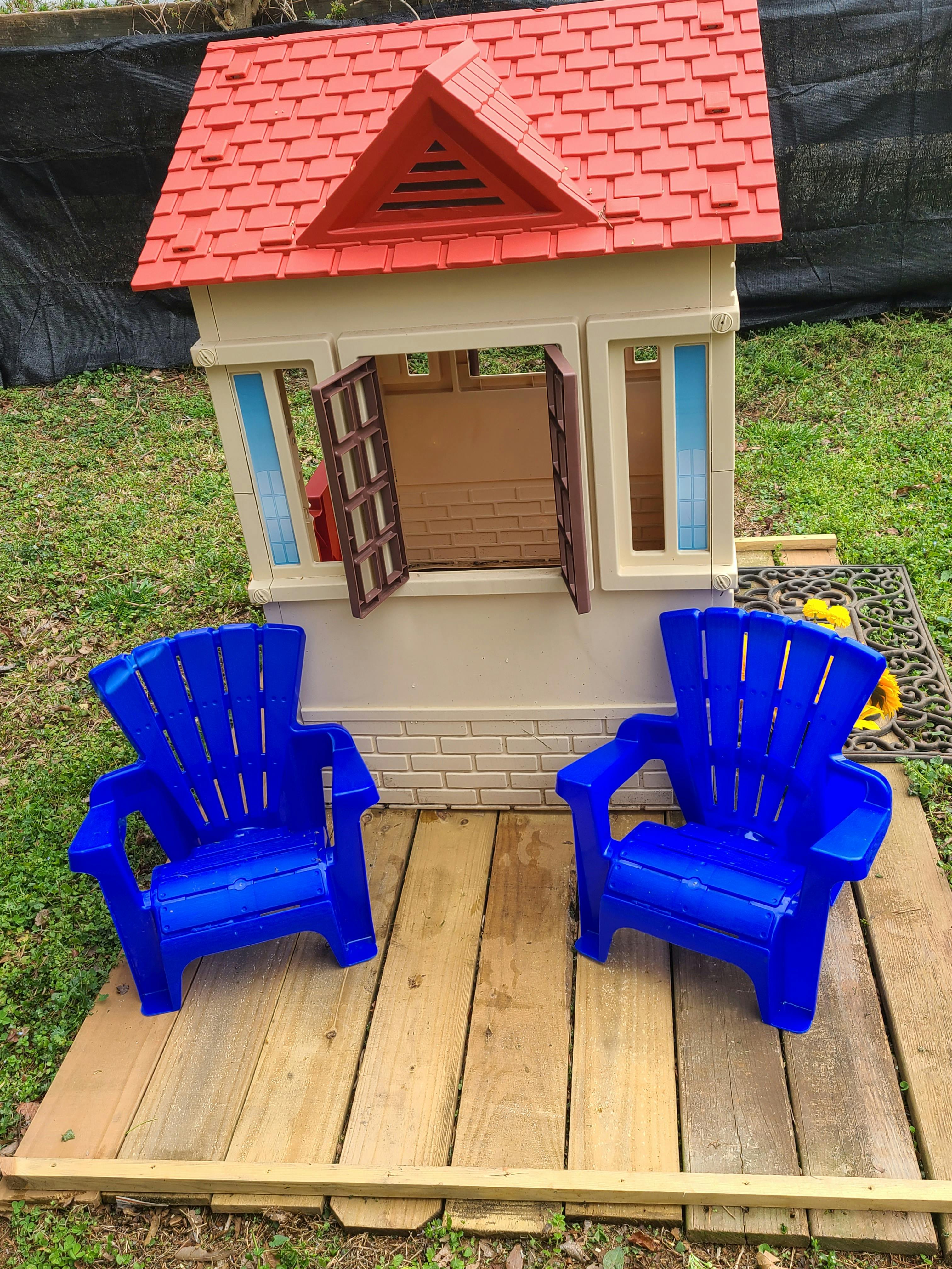 Playhouse with two blue chairs on a wooden platform