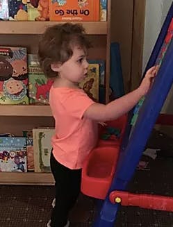 Child drawing on an easel