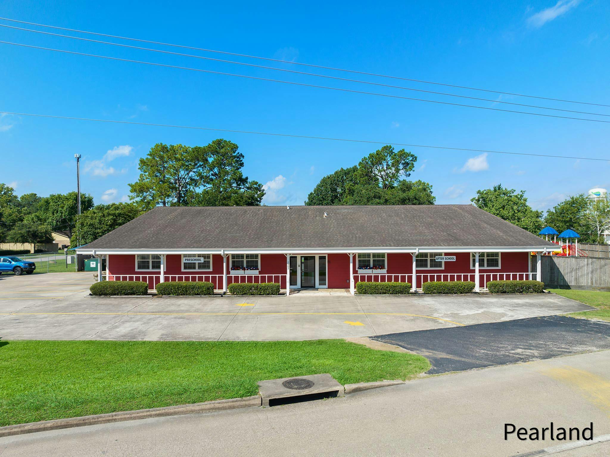 Red building with a white porch and a gray roof