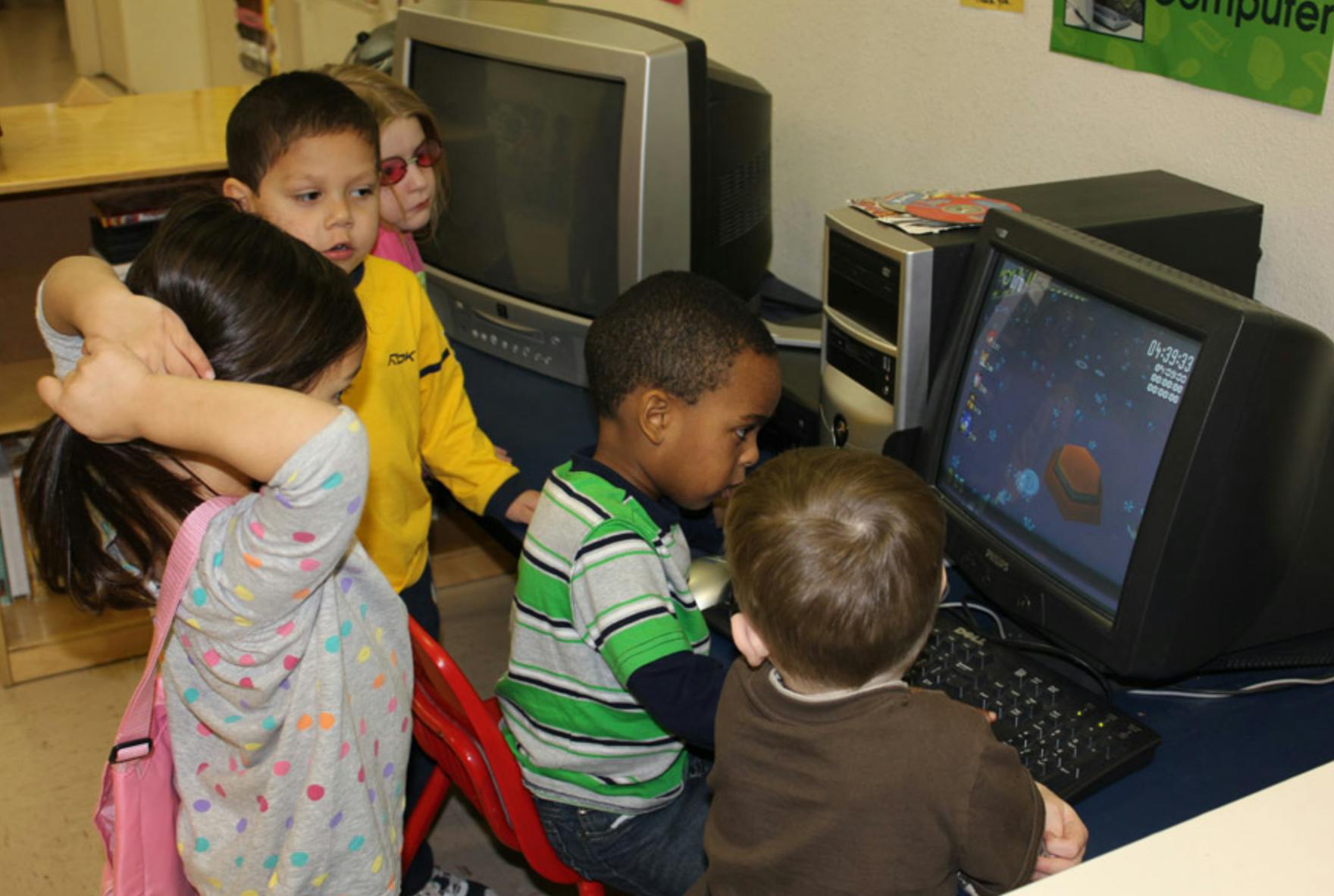 Children gathered around a computer