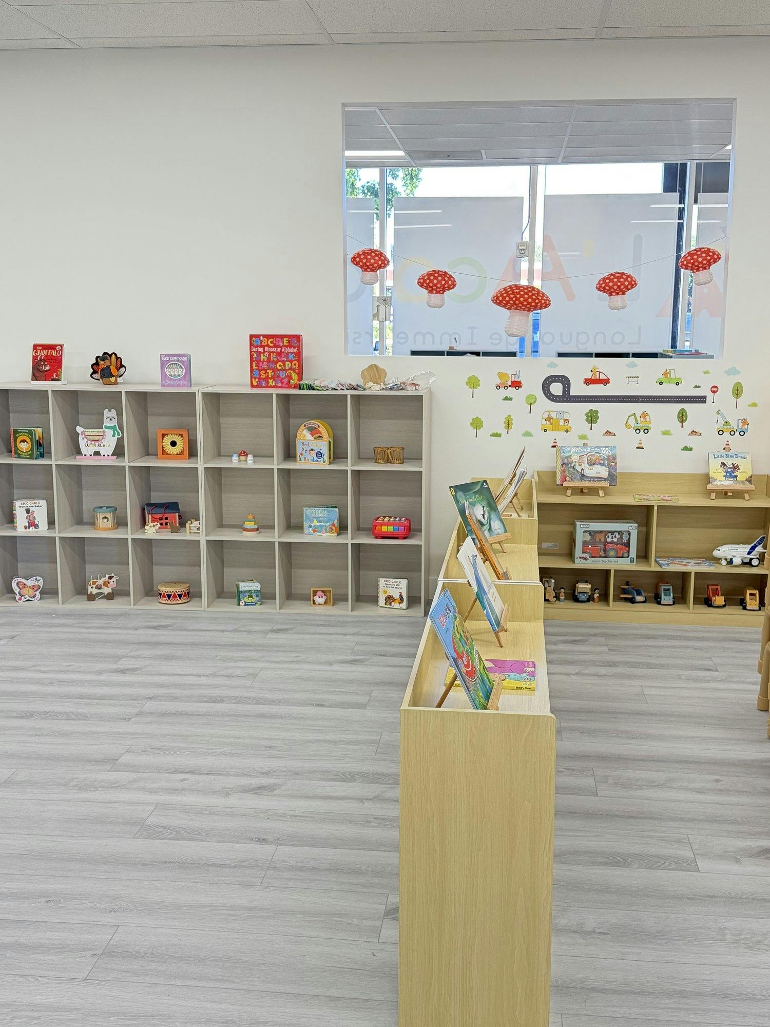 Classroom with shelves of children's books and toys, mushroom decorations