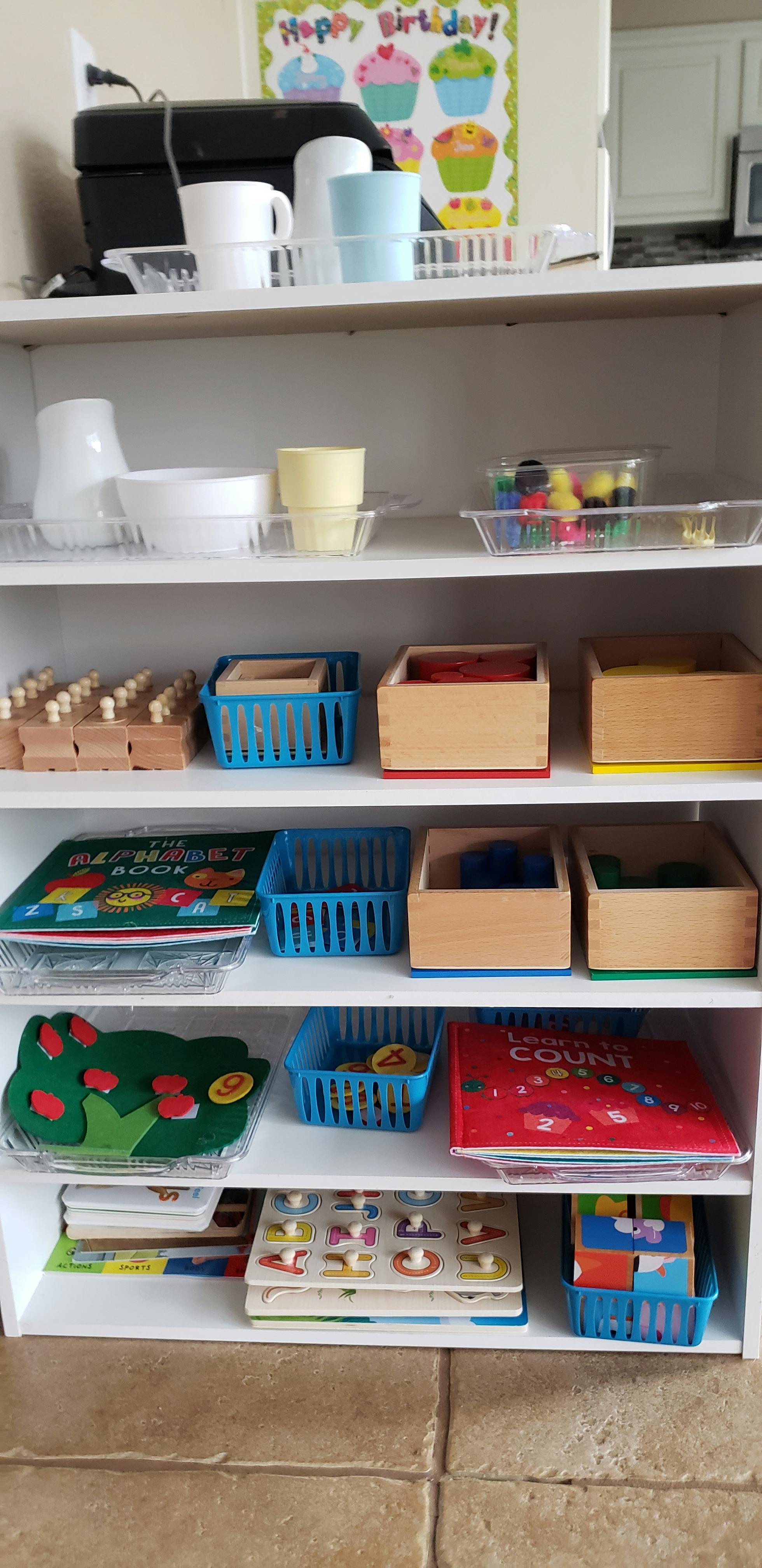 White shelving unit with various educational toys and materials