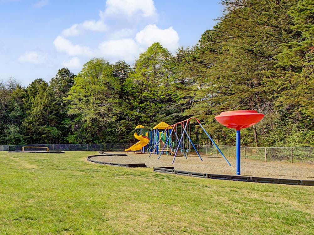 Playground with yellow slides, swings, and a red spinning toy