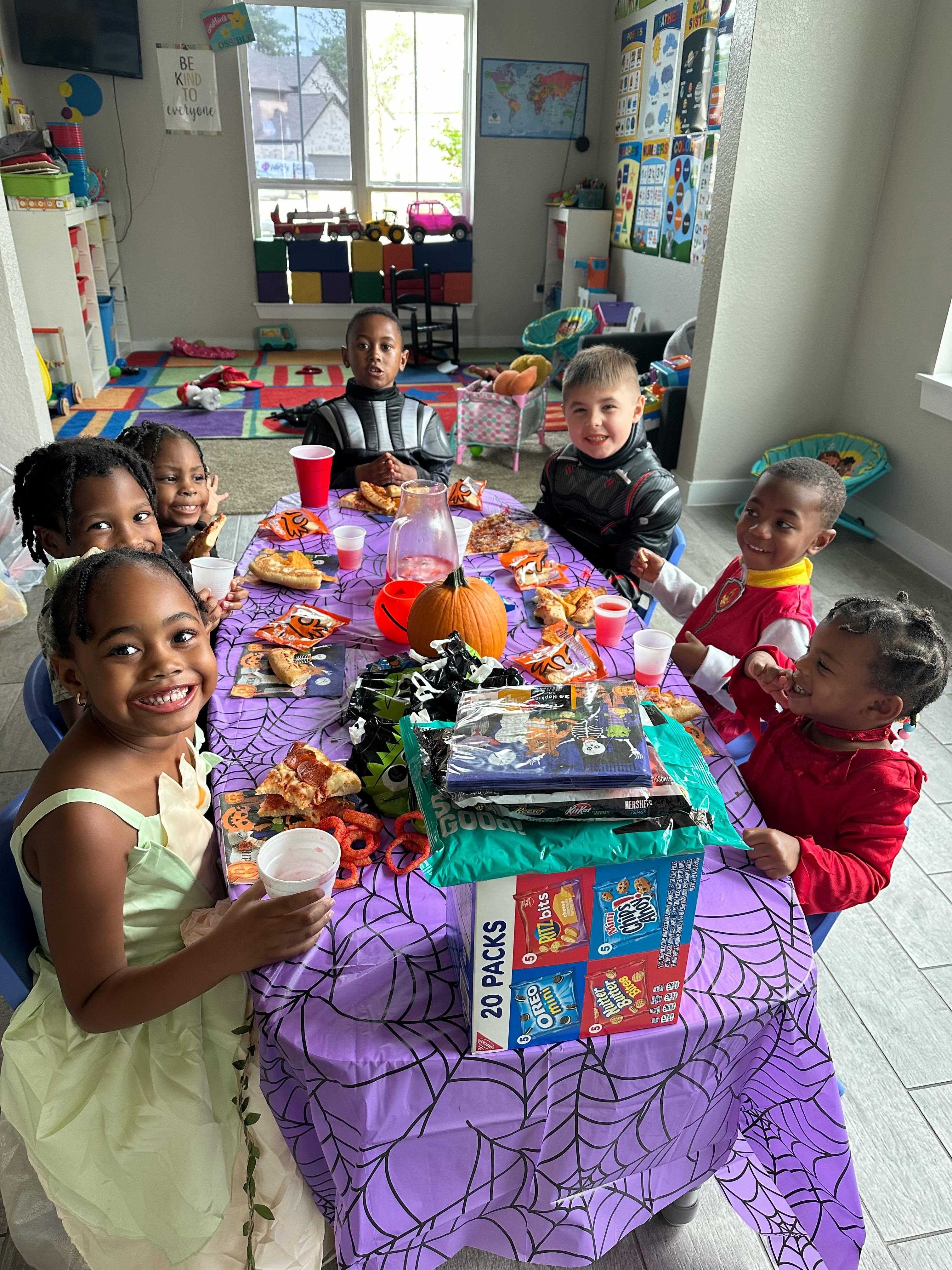 Children sitting around a table with food and drinks