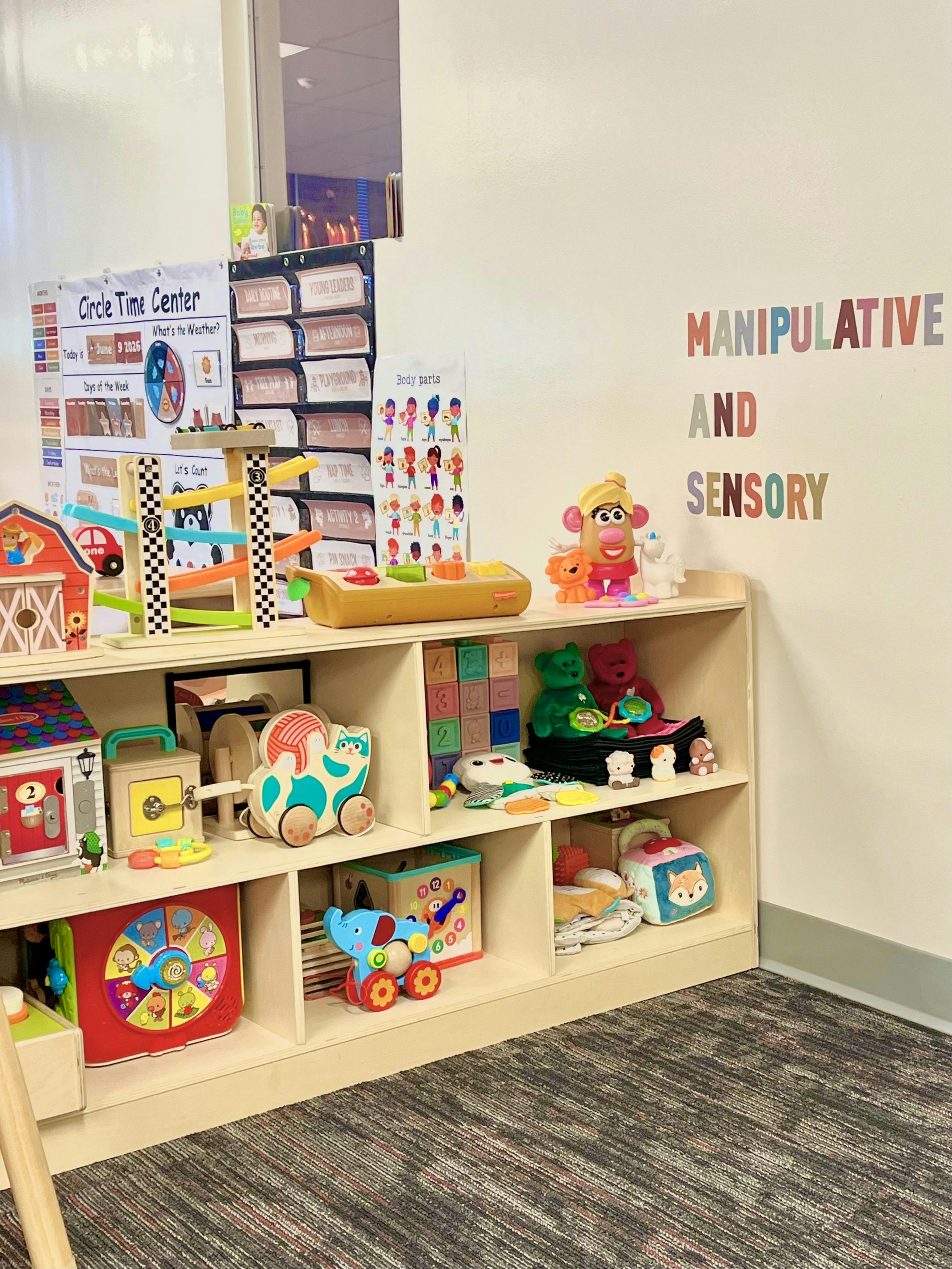 A wooden shelf filled with children's toys in a classroom sensory classroom area