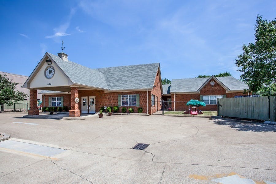 Brick building with a covered entrance and a small playground