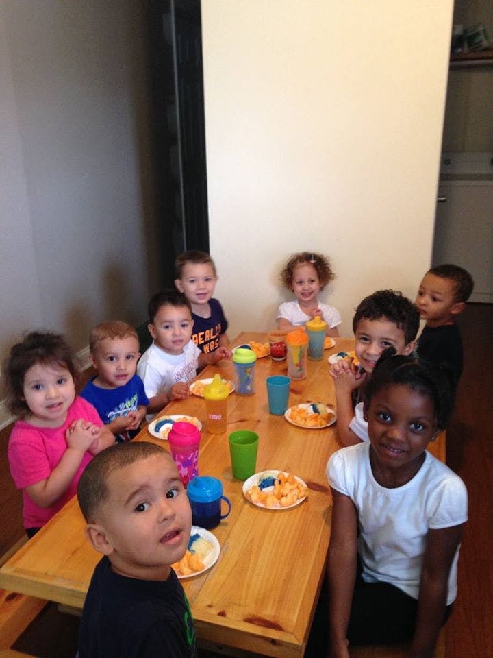 Children sitting at a table with plates and cups