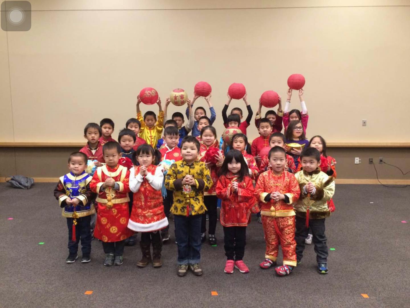 Group of children in traditional clothing holding red balls