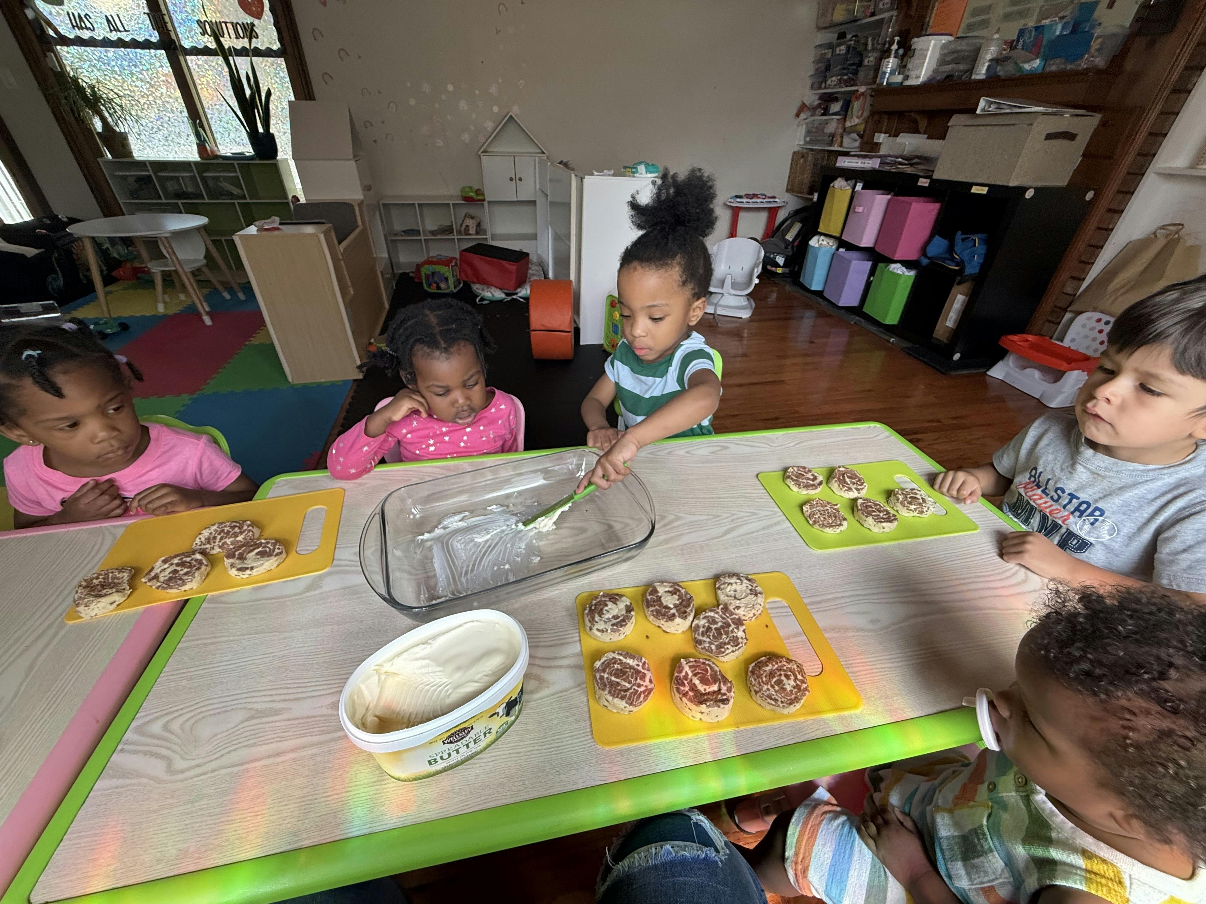 Children at a table decorating cupcakes