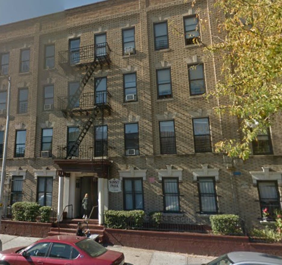 Brick apartment building with fire escape and person entering