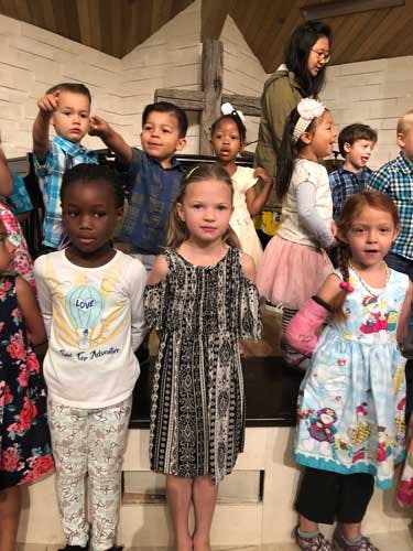Group of children standing together, some looking at the camera