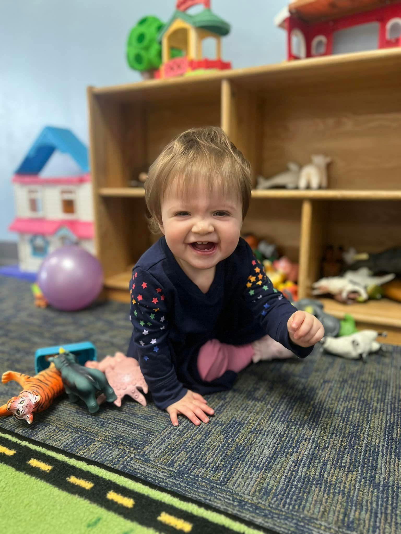 Child on floor with toys in a classroom