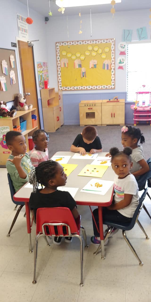 Children sitting at a table in a classroom
