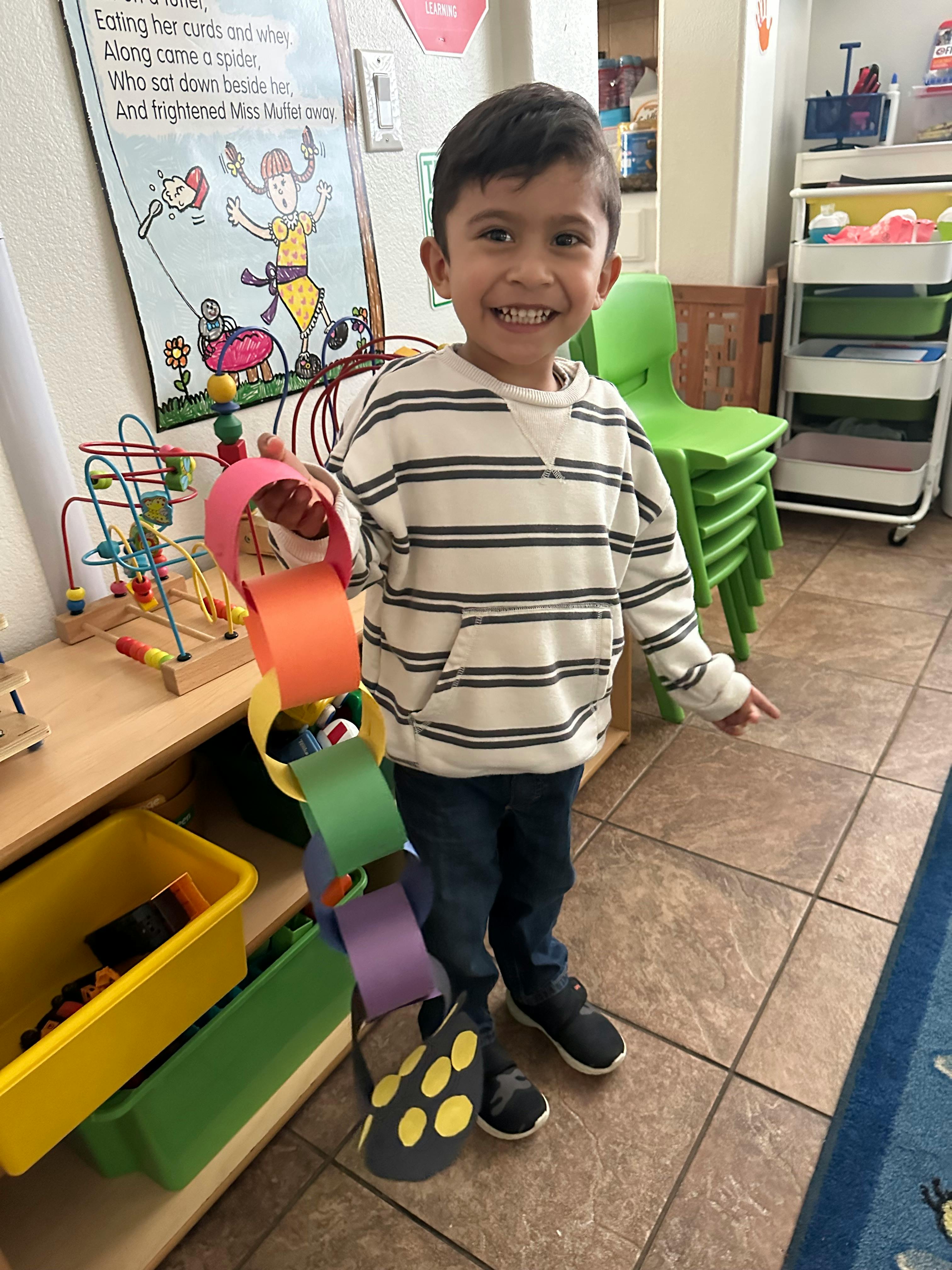 Child holding a paper chain in a classroom