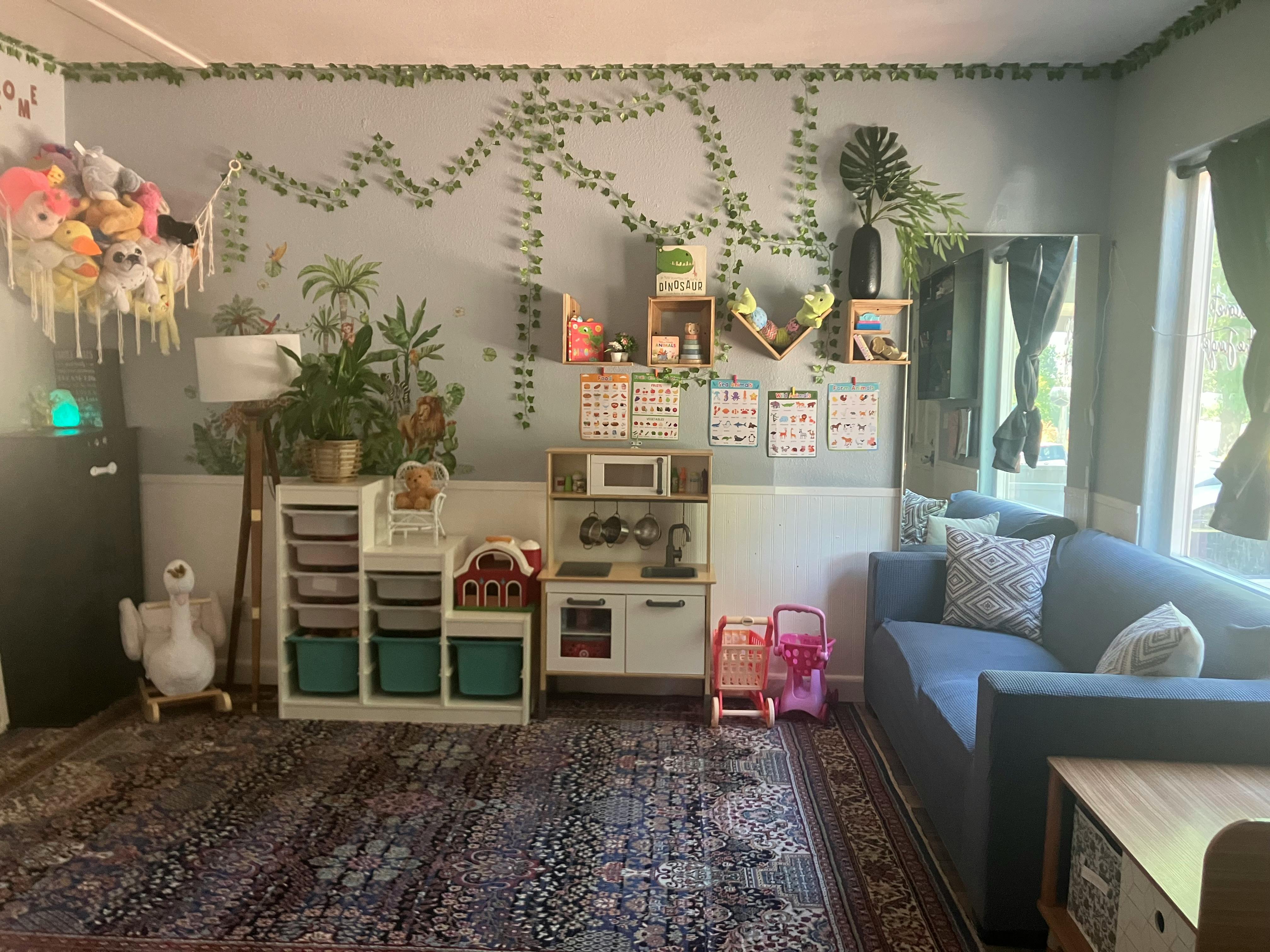 Playroom with toys, shelves, and small kitchen set on a rug