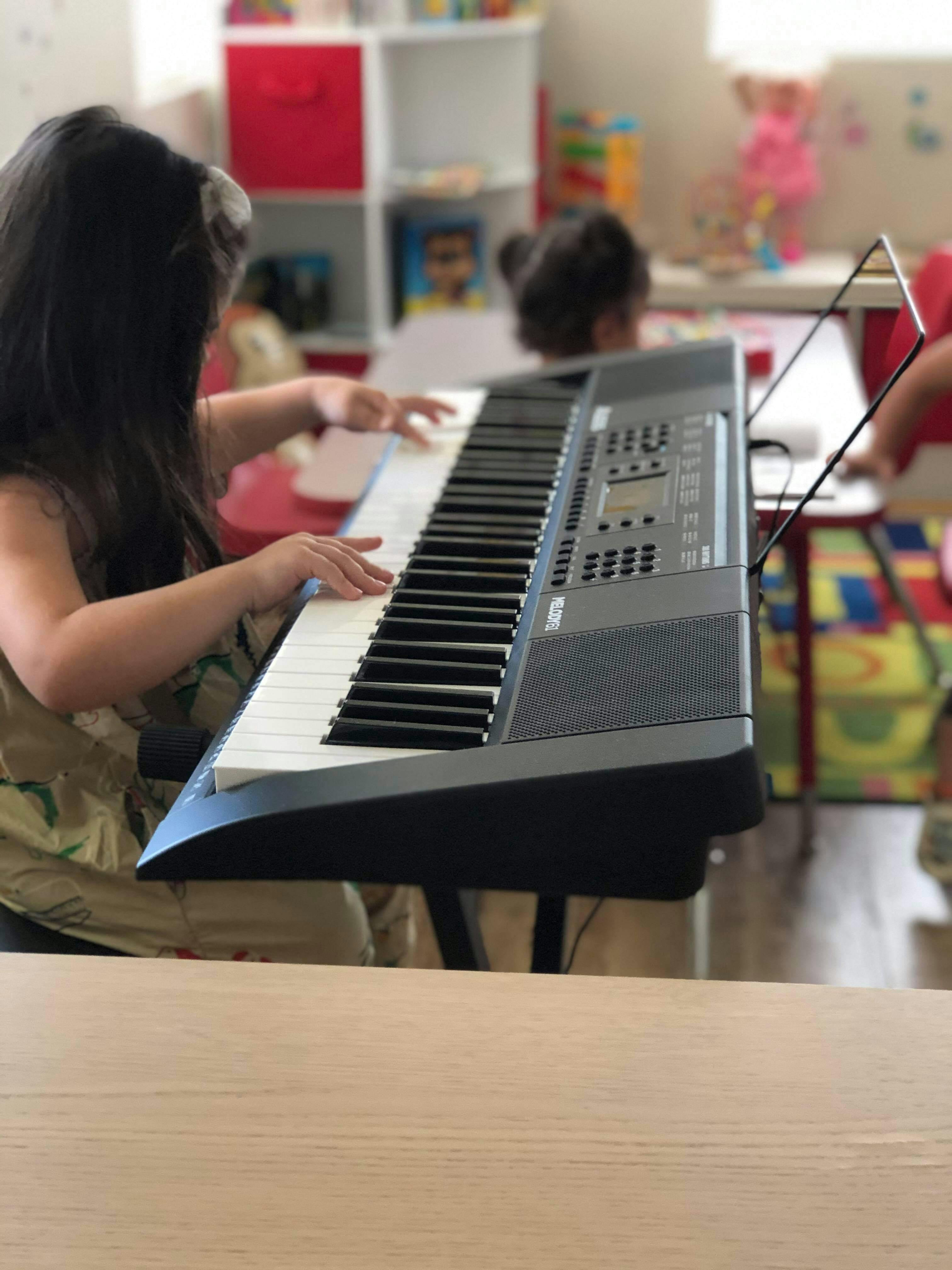 Child playing a keyboard in a classroom