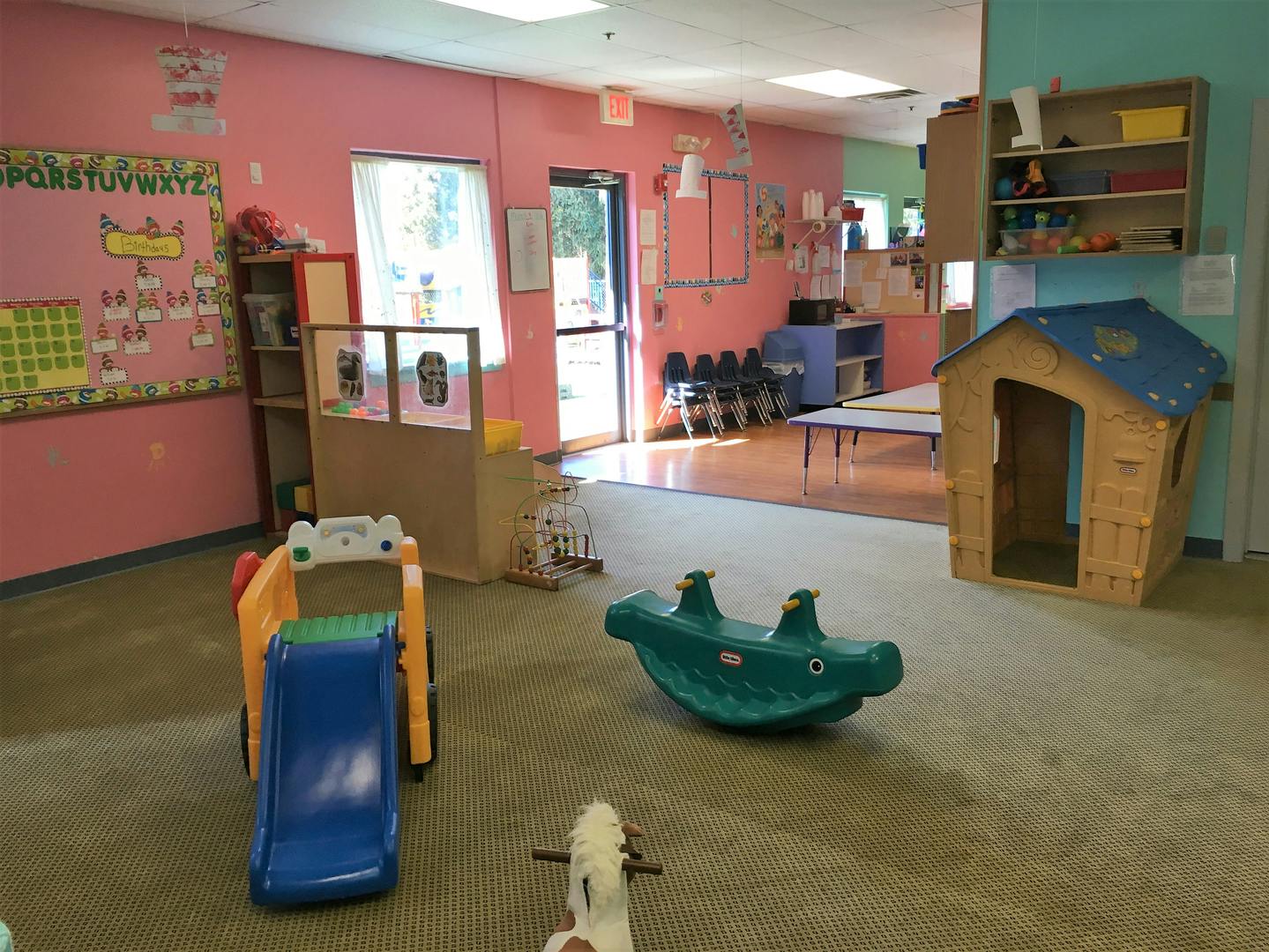 Indoor play area with slide, rocking toy, and playhouse