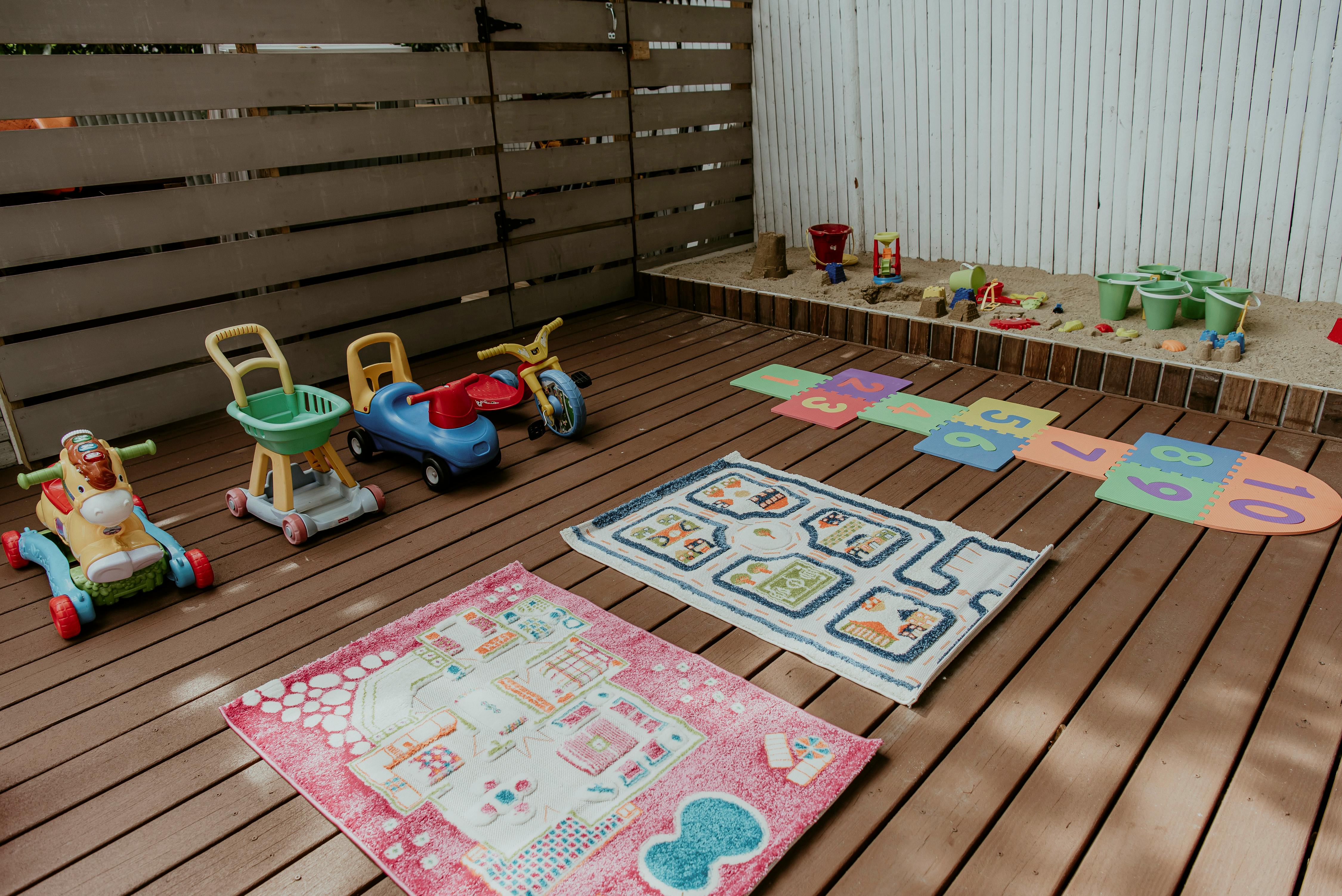Children's toys and play mats on a wooden deck