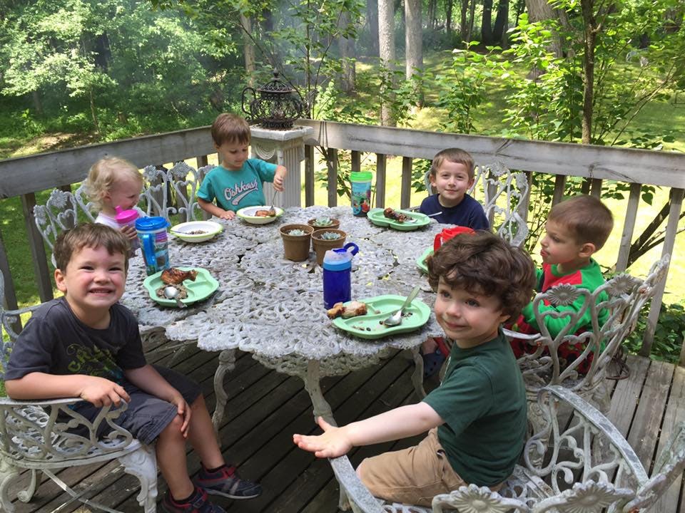 Children sitting around a table on a deck