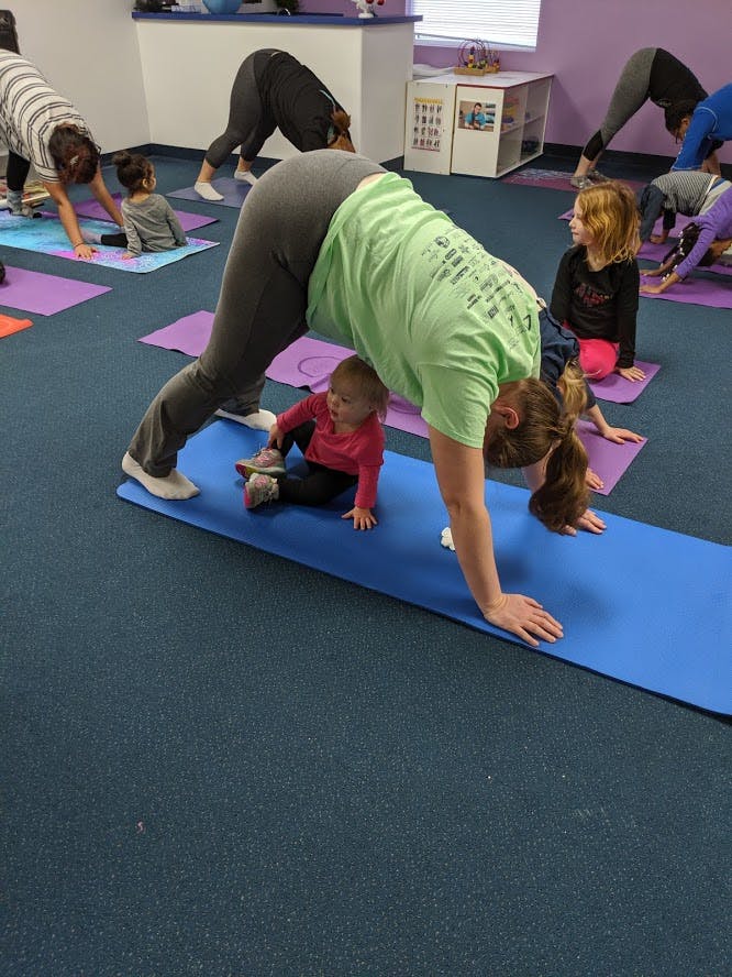 People and children doing yoga poses on mats