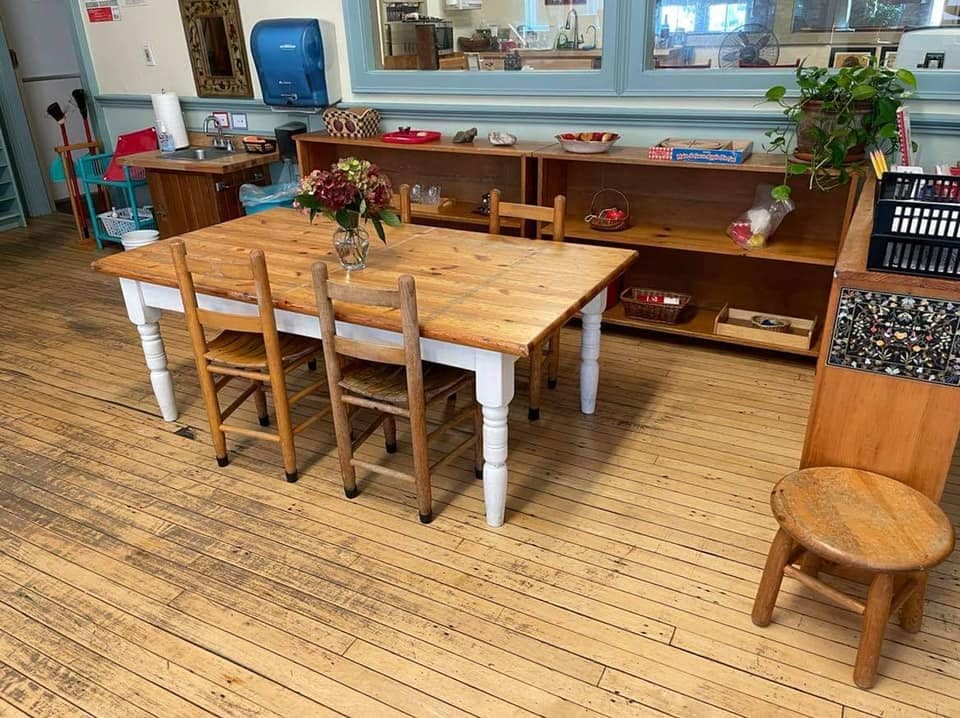 Wooden table with chairs in a room with shelves
