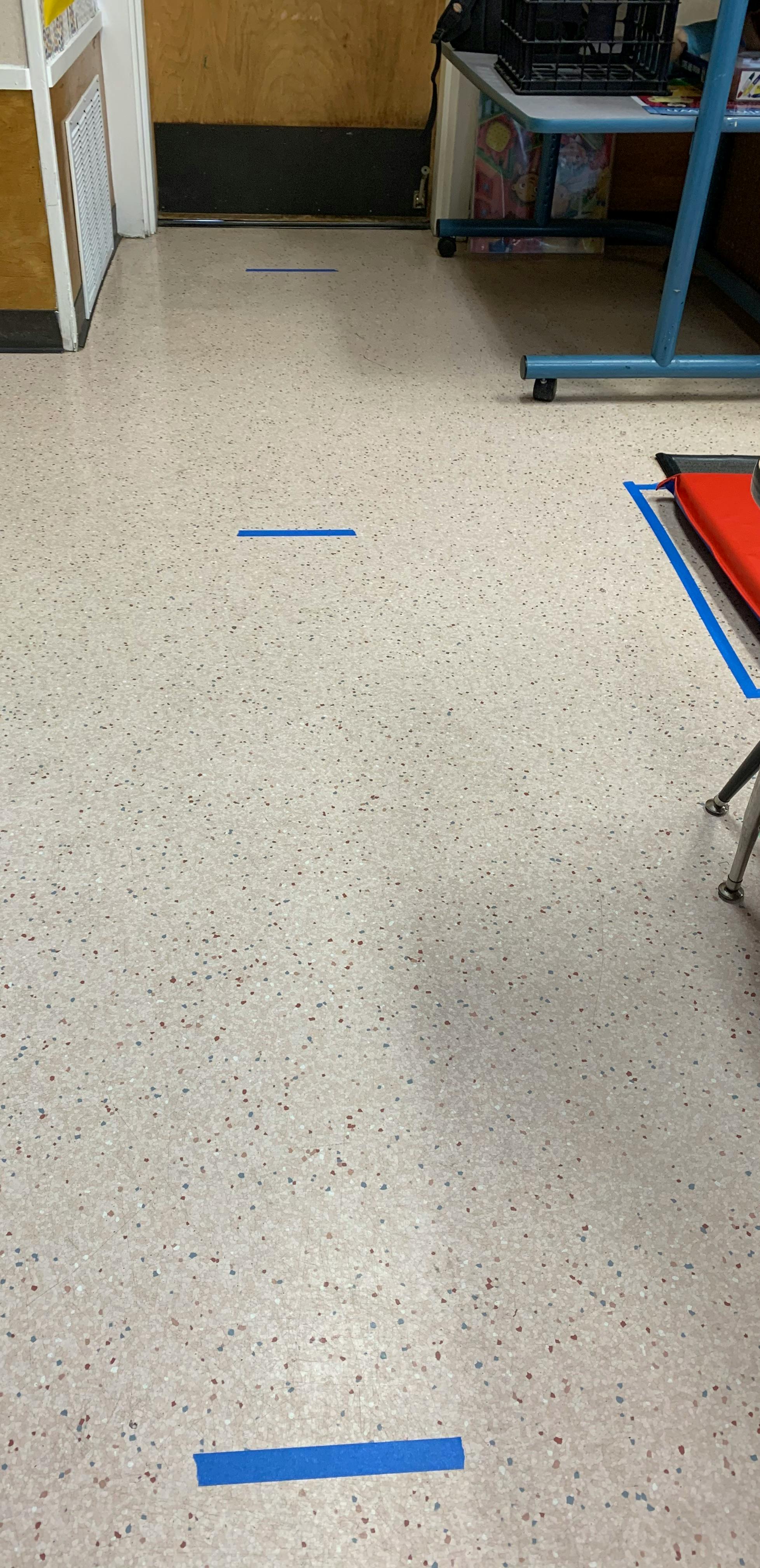 Blue tape lines on a light-colored floor