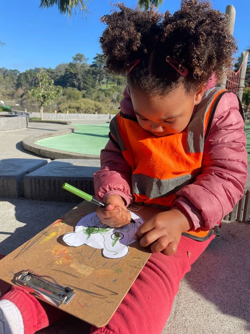 Child drawing on paper with a marker