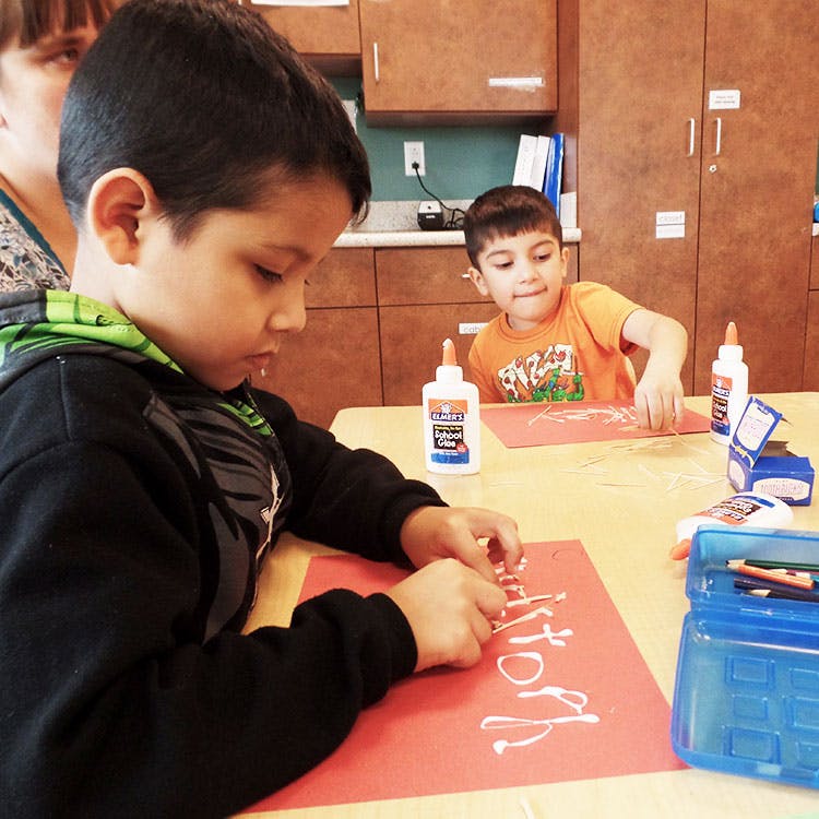 Two children doing crafts at a table