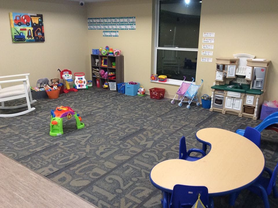 Playroom with toys, a small table and chairs, and a rocking chair